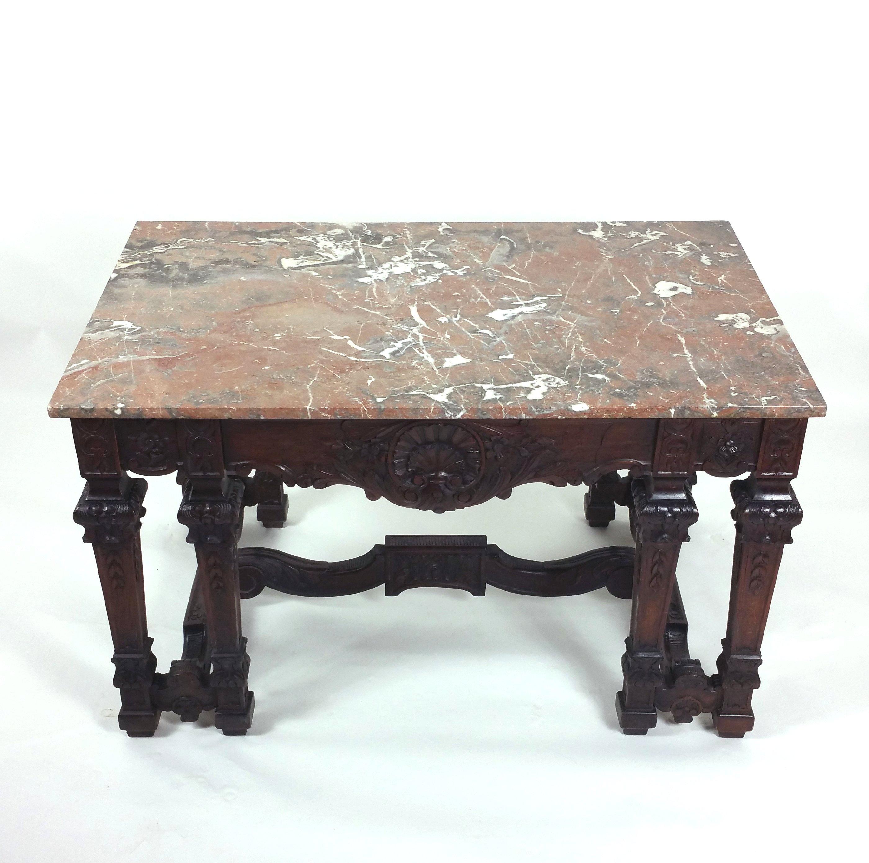 This lovely and well-proportioned mid-19th century. French walnut centre table features a reddish brown marbled top with ornate carved detailing. It stands on twin leg supports with an ‘H’ frame shaped base. The table measures 48 in – 122 cm wide,