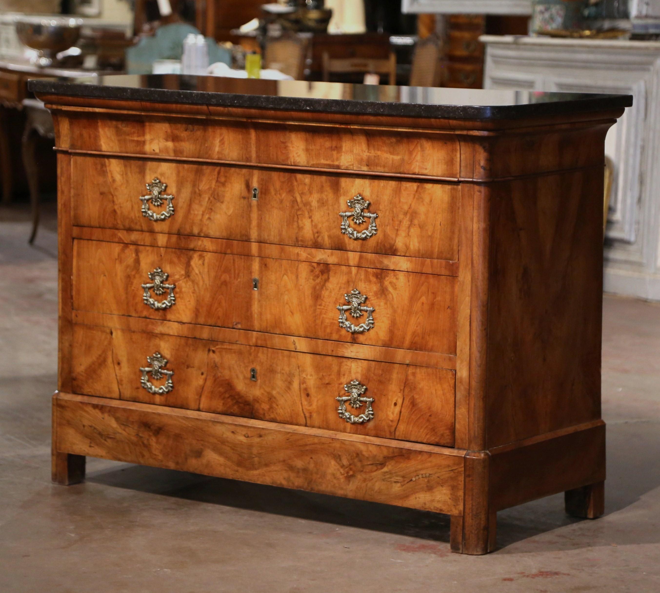 This elegant, antique chest of drawers was crafted in France, circa 1870. Built of walnut, the traditional commode with simple lines stands on shaped feet over a thick and raised base plinth; the cabinet features four long drawers across the front
