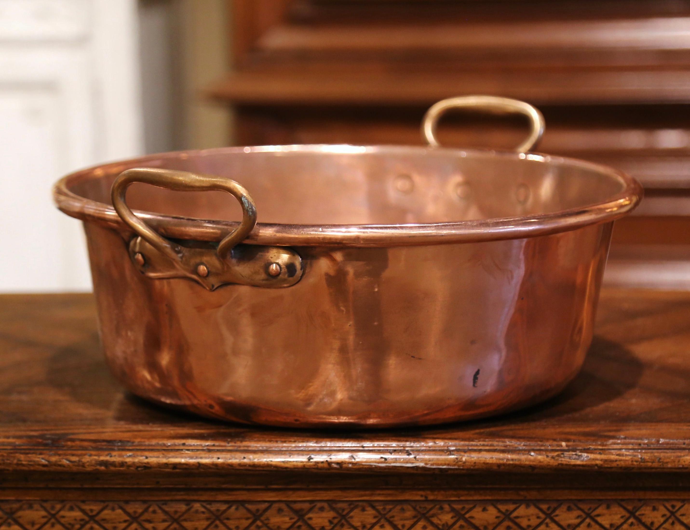 Bring an authentic French countryside touch to your kitchen with this large antique copper marmalade bowl. Crafted in Normandy, France, circa 1870, the decorative “Bassine a Confiture” (jam bowl) is round in shape and dressed with two brass handles