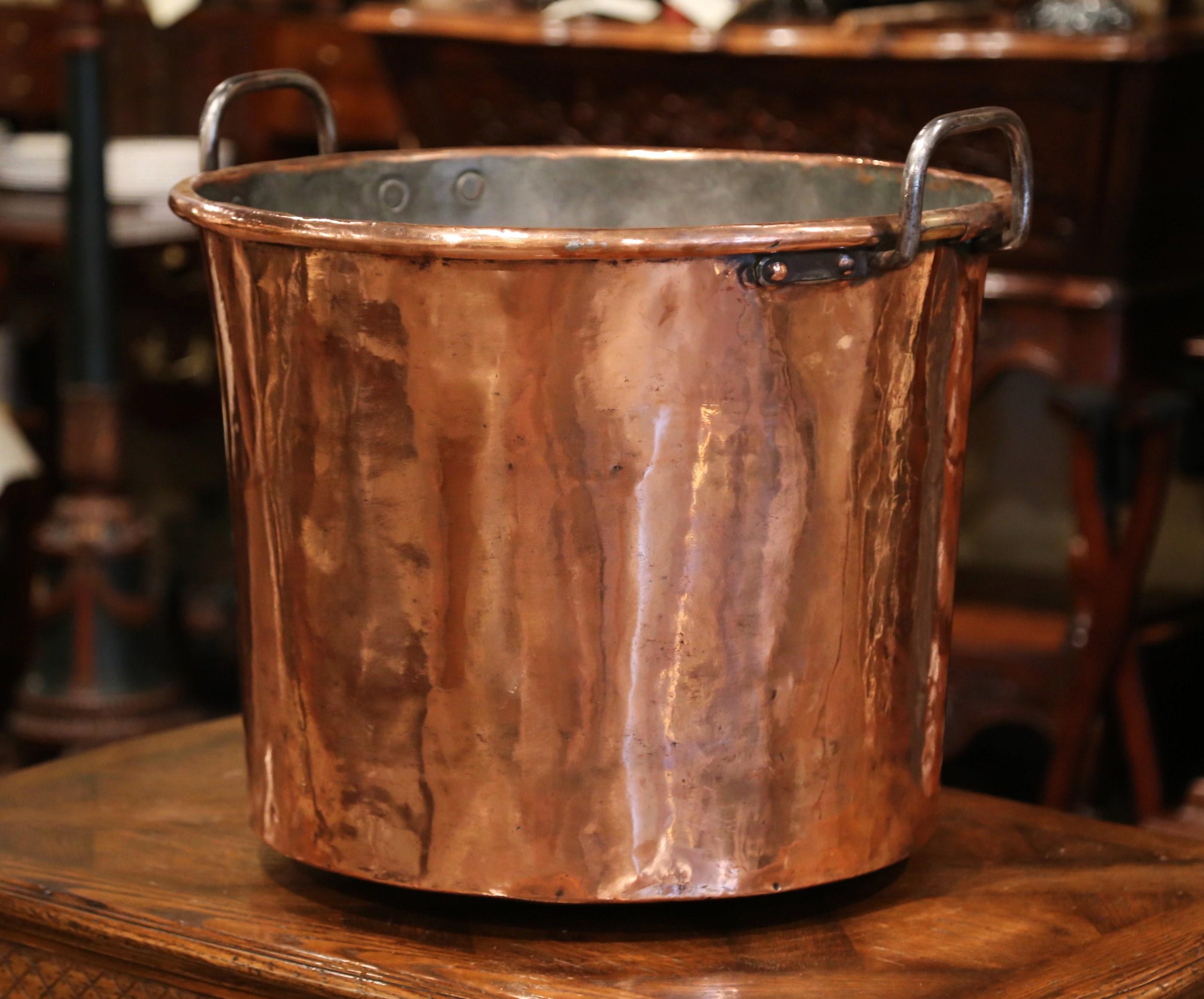 Keep your drinks cold in this important, antique, copper marmalade bowl! Crafted in Normandy, France, circa 1860, the large decorative“Bassine a Confiture”, or jelly bowl, is round in shape; it features two iron handles on the sides, which are