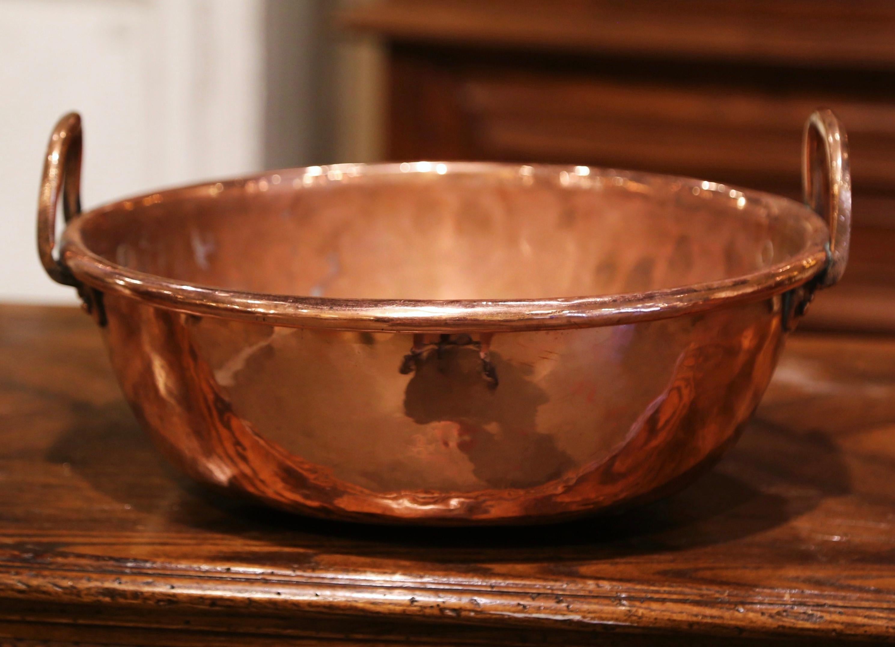 Bring an authentic French countryside touch to your kitchen with this large antique copper marmalade bowl. Crafted in Normandy, France, circa 1870, the decorative “Bassine a Confiture” (or jelly bowl) is round in shape and dressed with two brass