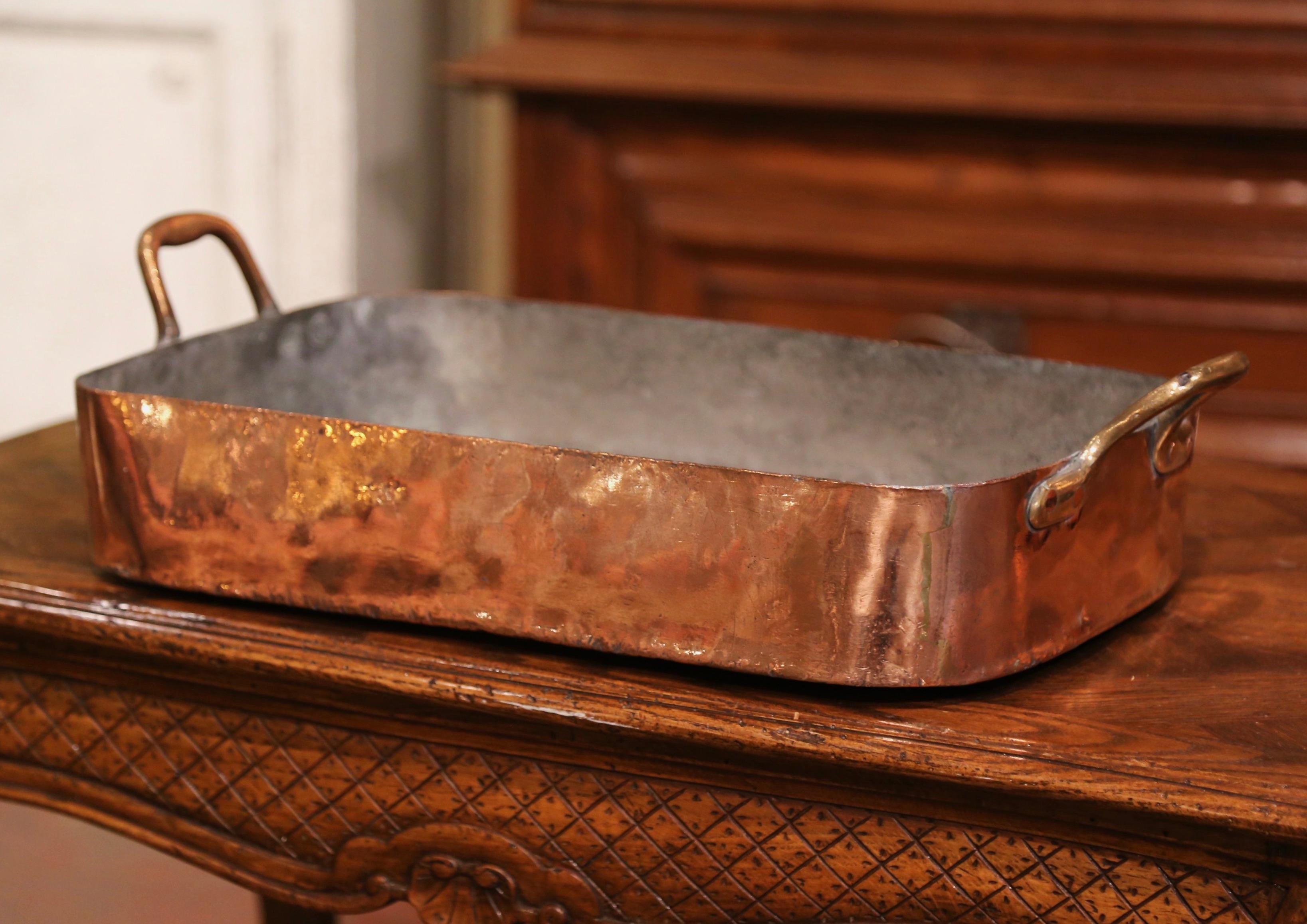 Bring an authentic French countryside touch to your kitchen with this large antique copper food dish. Crafted in Normandy, France, circa 1870, the decorative dish is rectangular in shape and dressed with two brass side handles attached with rivets.