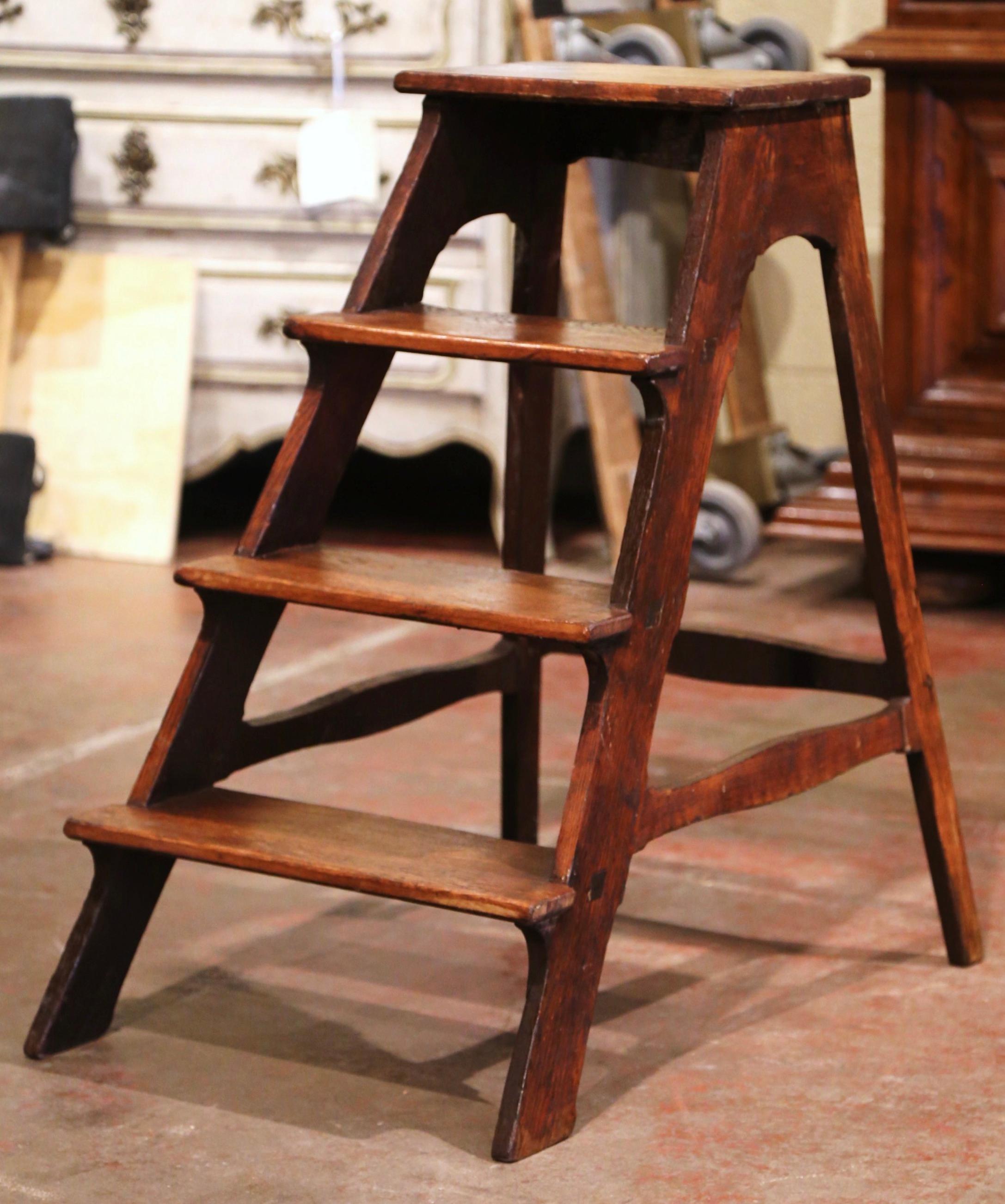 This elegant antique step ladder was created in France, circa 1850. Carved of solid oak, the sturdy ladder features four steps including a wider and deeper step at the top. Practical and useful, the rustic ladder is in excellent condition