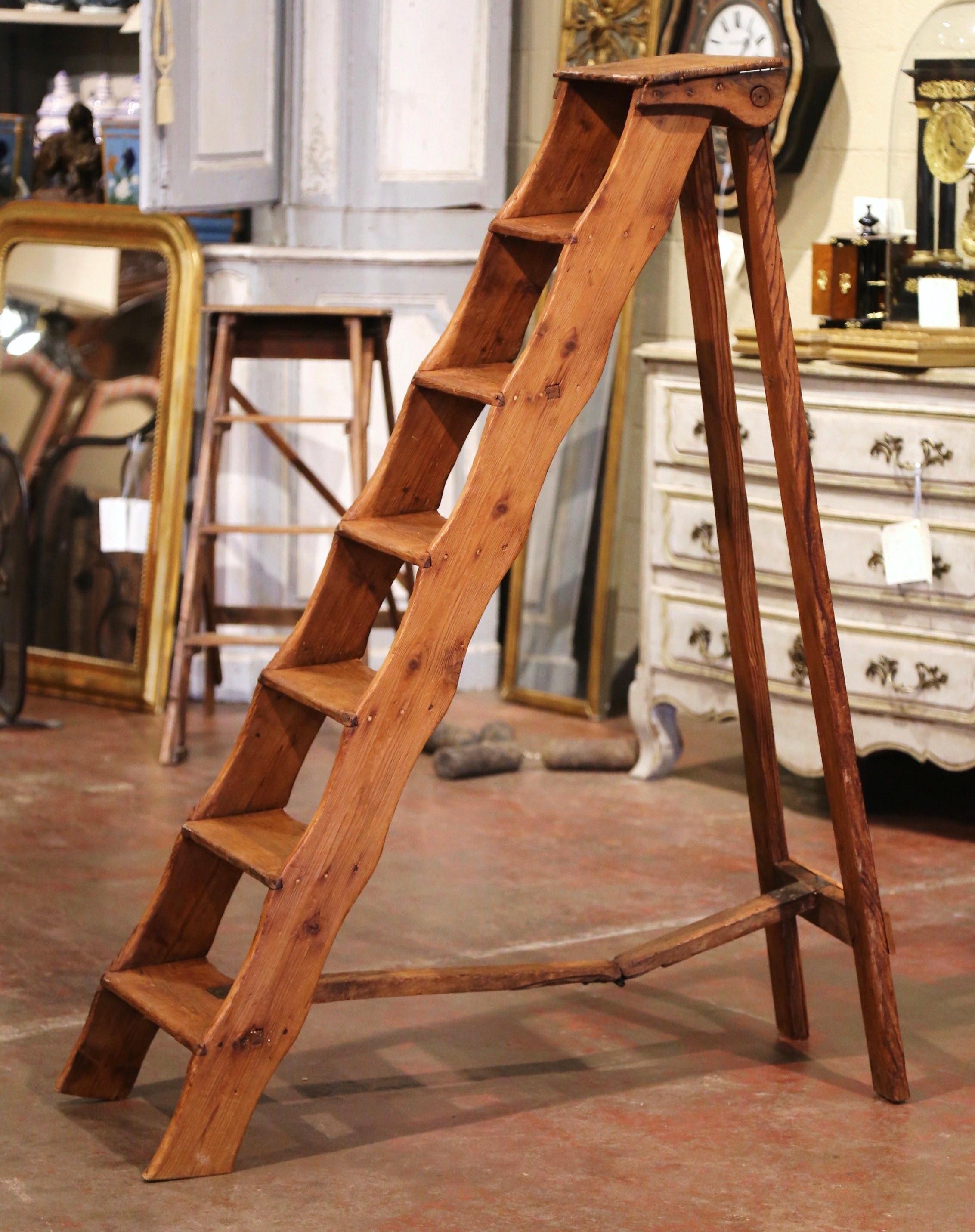This elegant six foot antique ladder was created in Northern France, circa 1850. Made of solid pine, the sturdy step ladder features seven steps including a wider and deeper step at the top. Practical and useful, the rustic ladder can be put away by