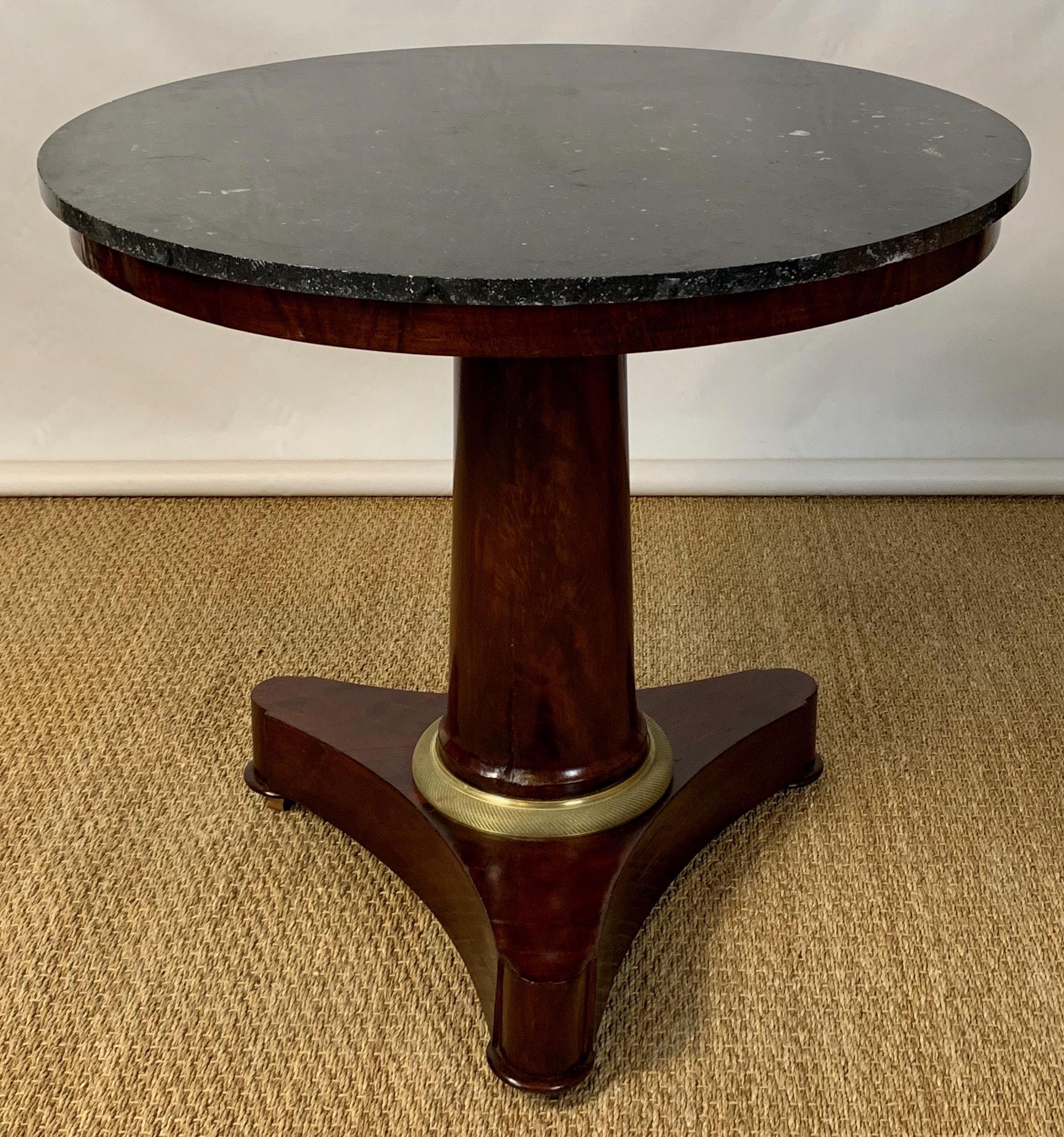 A classic and very elegant mid-19th century French Empire period mahogany and marble topped center table with gilt ormolu mounts. The fossilized black marble appears to be original to the piece.