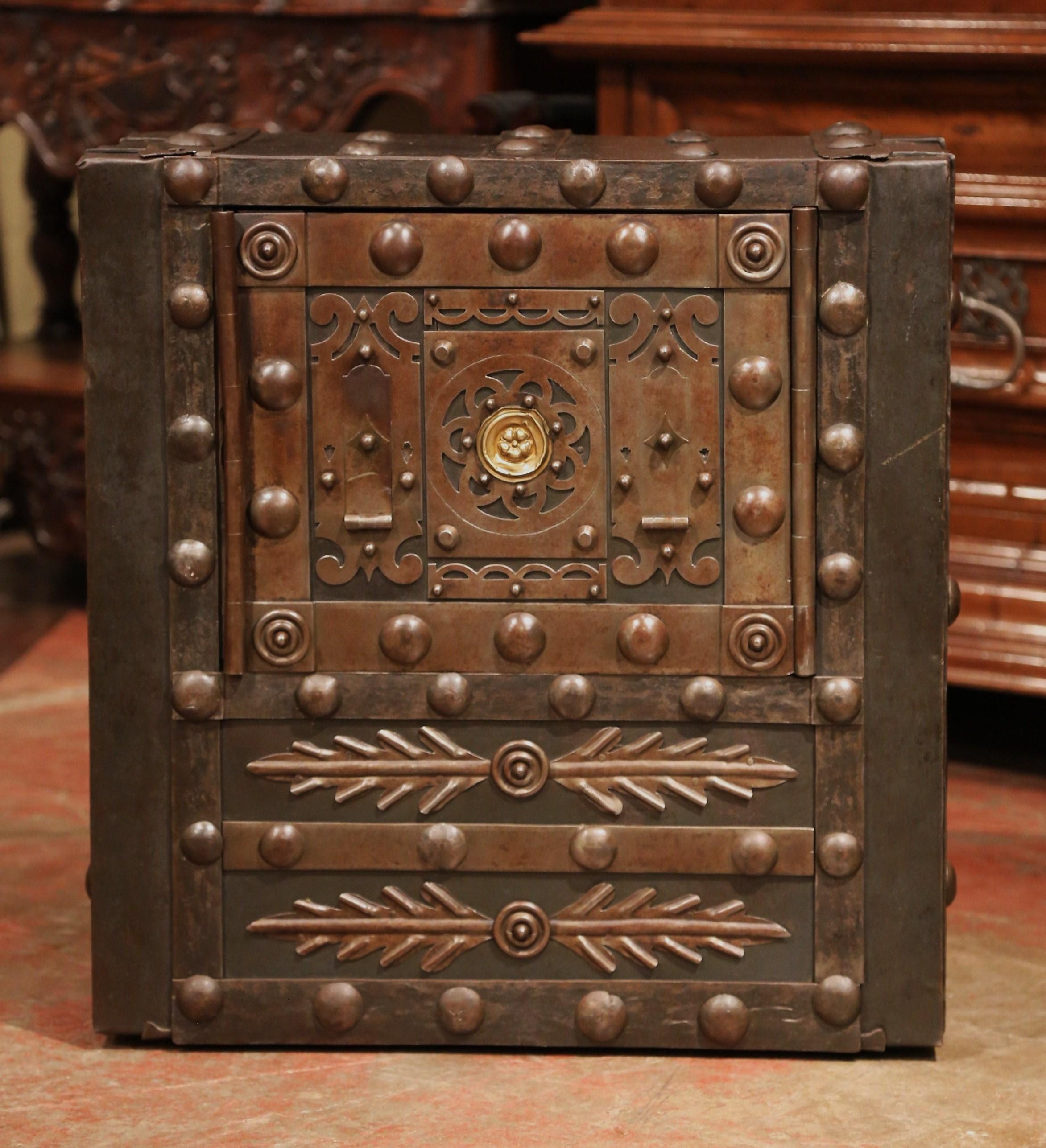 Keep your important valuables in this antique Gothic safe, created in France, circa 1860, the forged safe is made of iron and embellished with hobnail stubs on all sides and decorated with leaves under the door. The cabinet features a central door