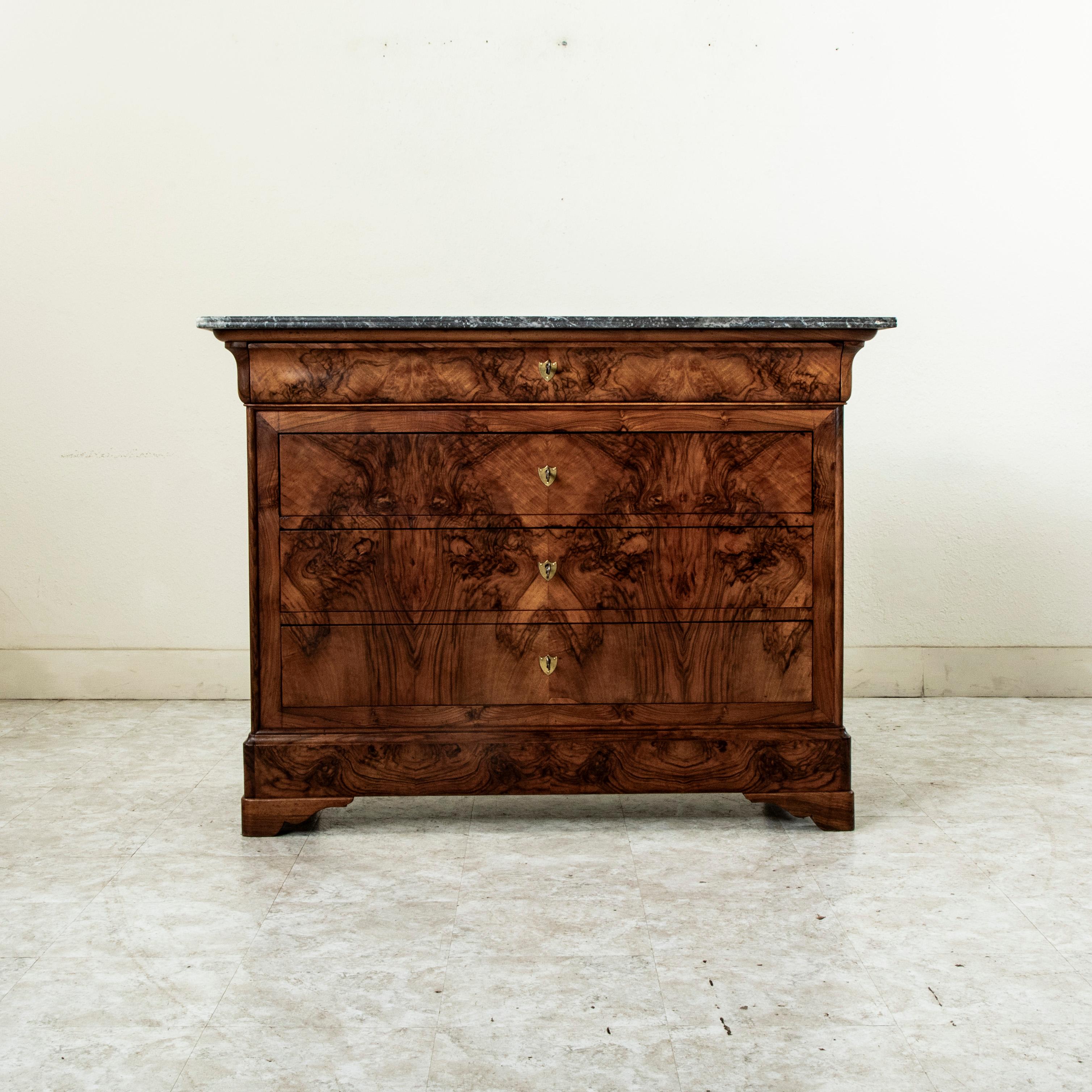 This quintessential Louis Philippe period commode or chest of drawers displays the exemplary craftsmanship of the nineteenth century with a facade of book matched walnut and solid walnut panel sides. The piece is capped with a double beveled Saint