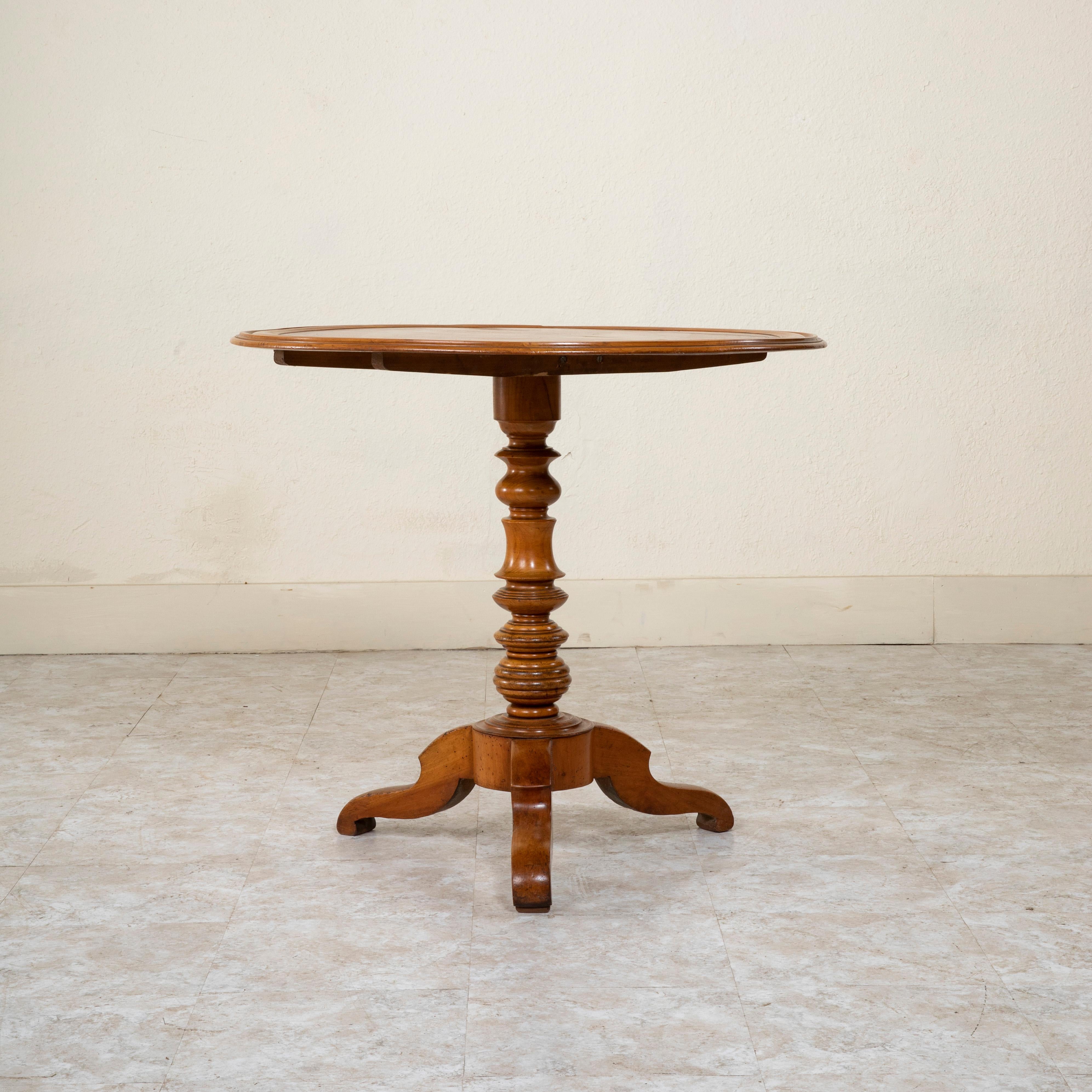 Constructed of walnut, this French Louis Philippe period gueridon or pedestal side table features a multi beveled top with concentric rings of ebonized pearwood. The top rests on a central turned pillar supported by a tripod base. An ideal table to