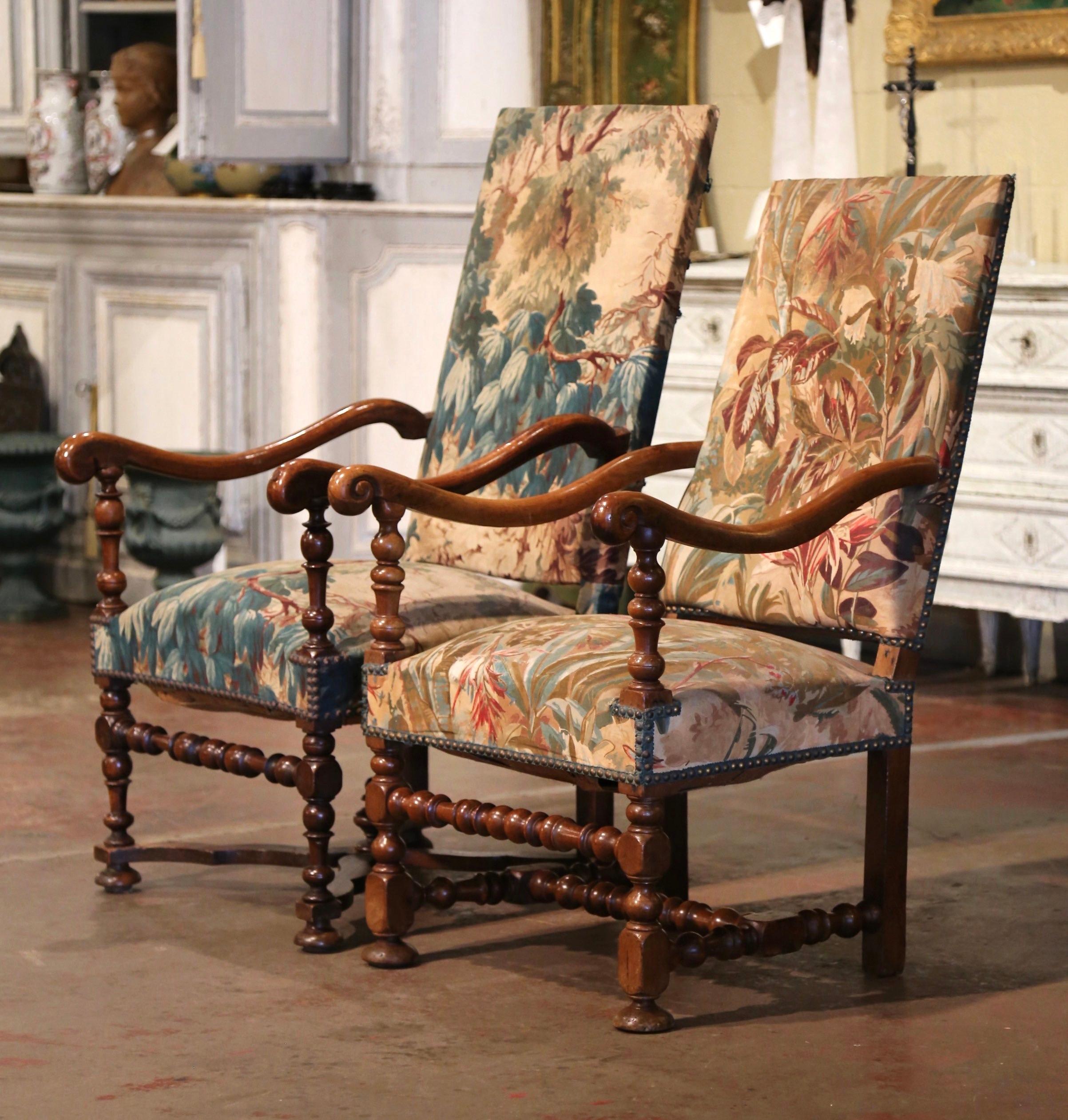 Decorate a den, a study or an office with these two antique walnut armchairs. Crafted in Southern France, circa 1850, each tall fruitwood chair stands on straight turned legs over a bottom stretcher; the armchair features a tall rectangular and each