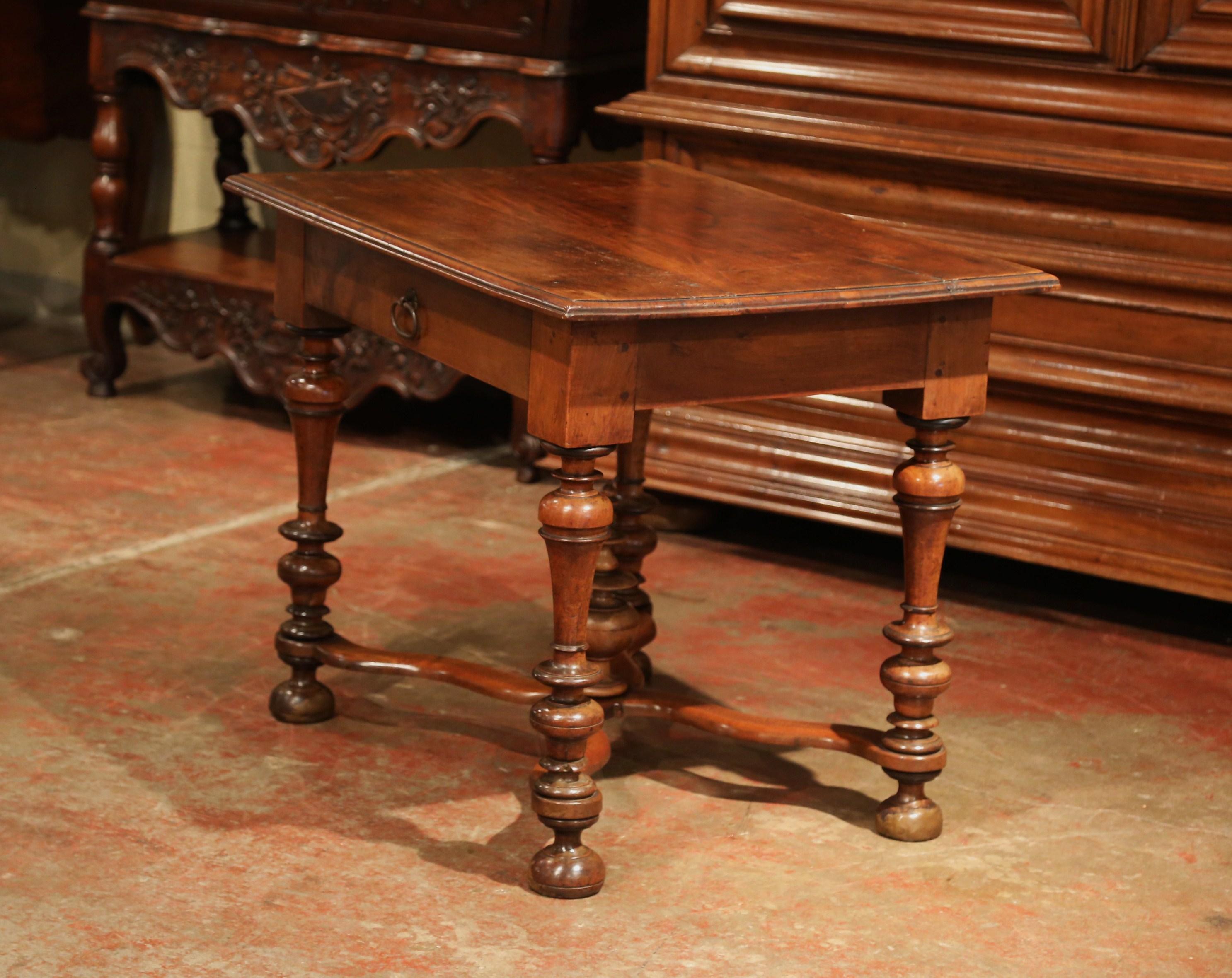 Incorporate extra, functional surface space into your living room with this elegant antique fruitwood table. Crafted in the Perigord region of France, circa 1860, the side table features a single drawer across the front that's embellished with its