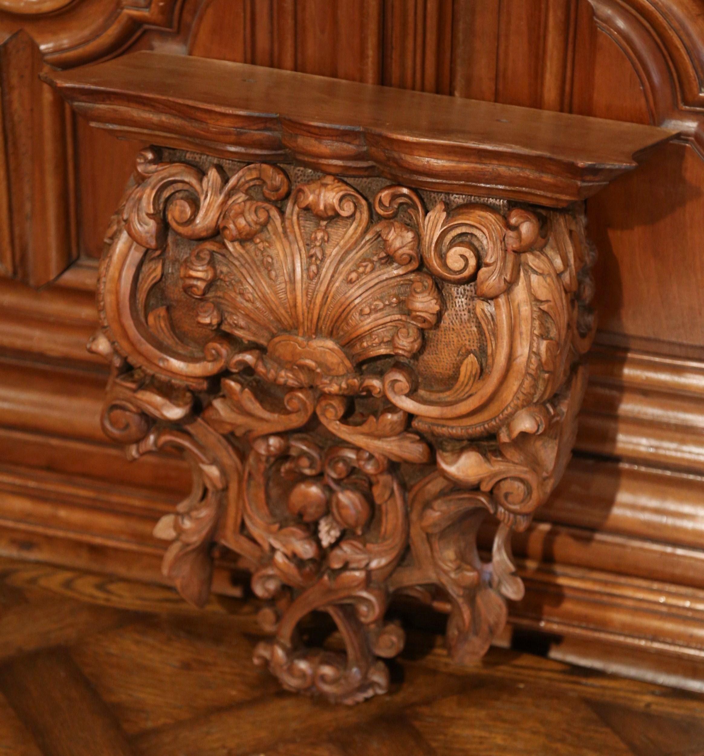 Place a bust or a vase on this elegant antique wall corbel; crafted in France of solid walnut wood, circa 1860, the large wall bracket features intricate hand carved motifs including scroll, leaf and fruit motifs, and embellished with a center shell