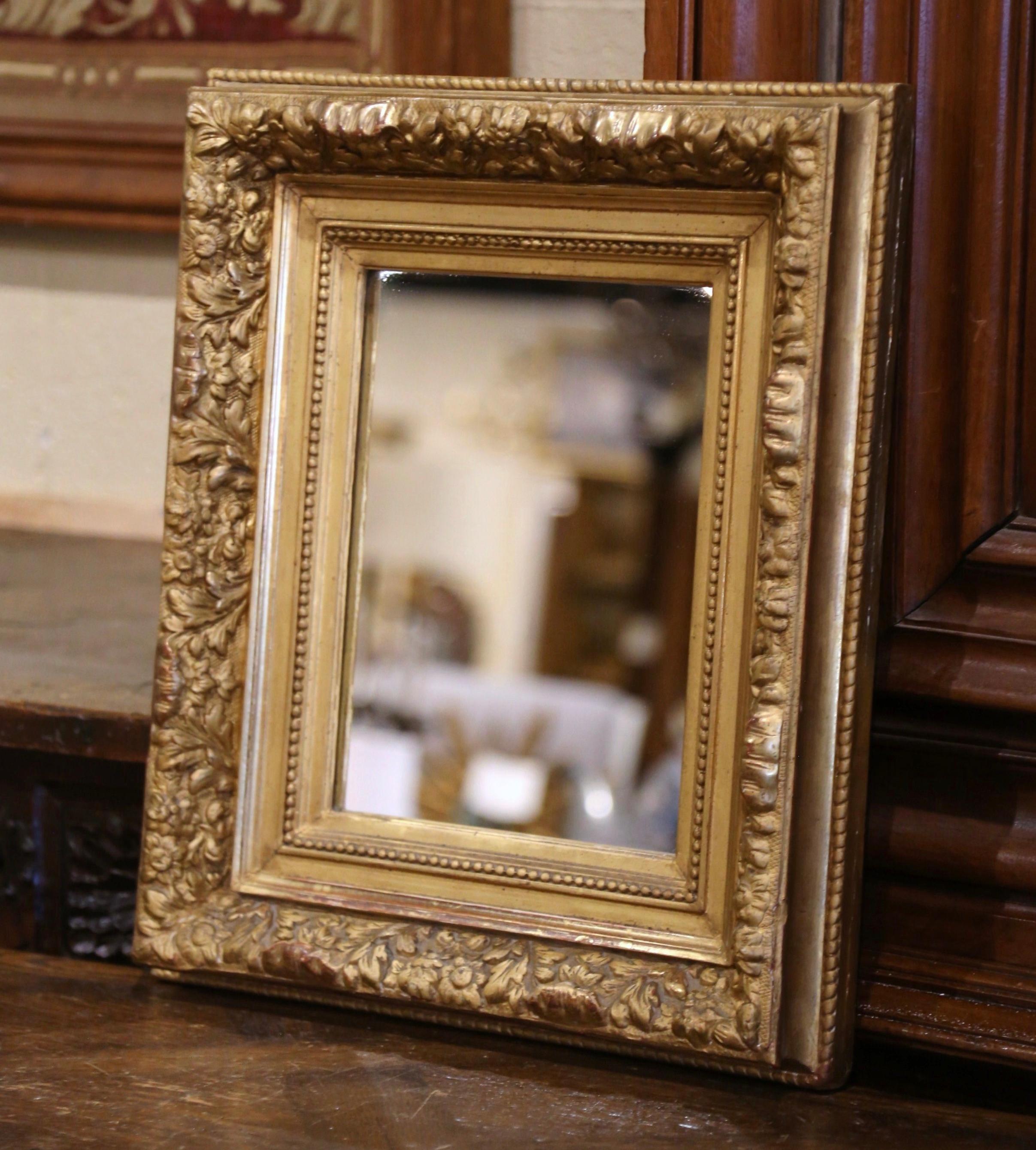 Decorate a hallway or small entry with this elegant antique gold leaf mirror. Crafted in the Burgundy region of France, circa 1860, the rectangular mirror has traditional lines with floral and leaf motifs in high relief; the thick frame is decorated
