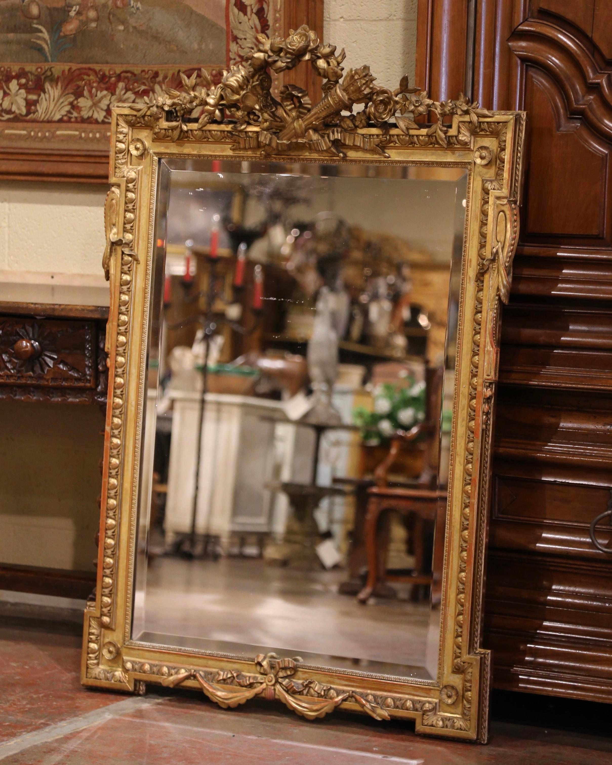 Decorate a powder room or an entry way with this elegant antique mirror! Crafted in France circa 1860, and rectangular in shape, the mirror features an intricate cartouche at the pediment embellished with crossed torches set inside a laurel crown,