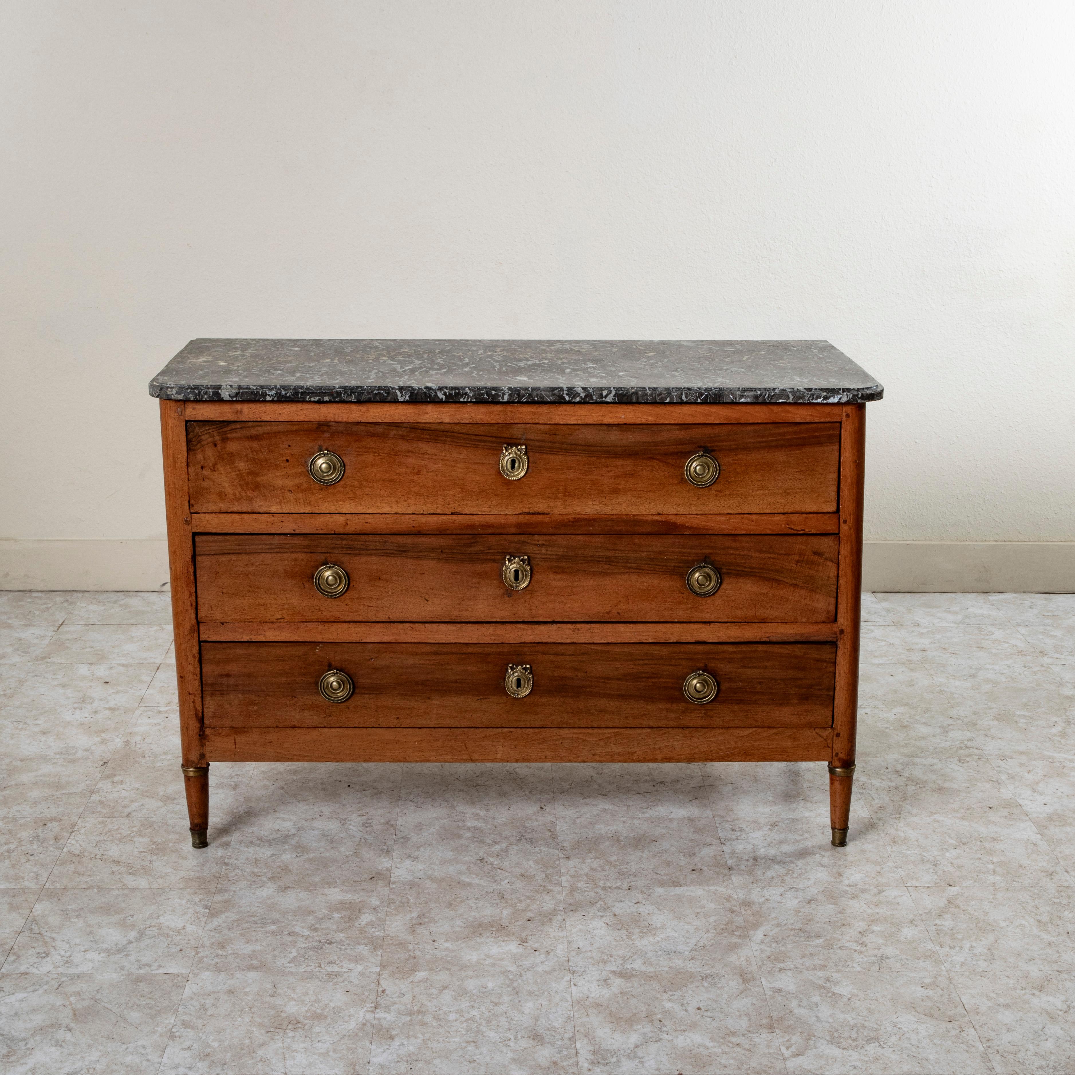 Questa cassettiera in noce in stile Saint Louis XVI della metà del XIX secolo presenta un piano in marmo di Saint Anne e angoli arrotondati. I tre cassetti con struttura a coda di rondine sono dotati di classici tiretti con maniglia a goccia e di