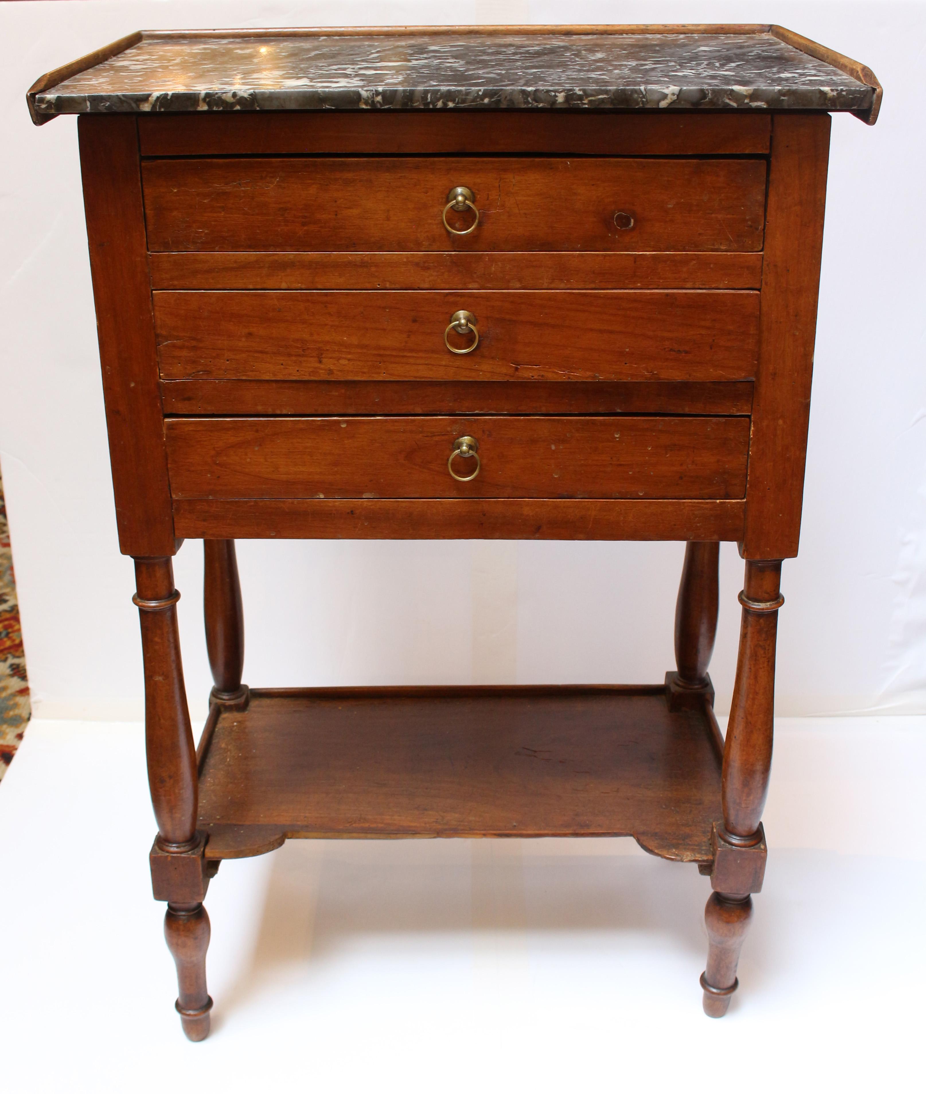 Mid-19th century marble top chevet (bedside table), French. Cherry wood. Louis Philippe. 3 drawers over shaped, molded edge lower tier, following the design of the top. Ring turned vasi-form legs ending in faux sabots. 19 3/4