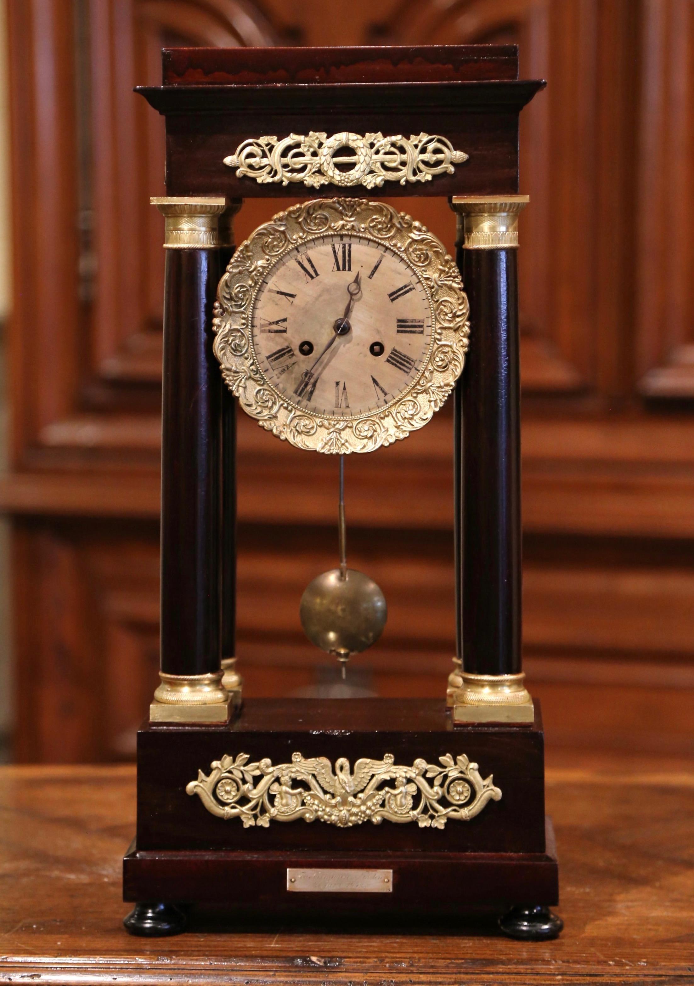 Keep time in your office, study, or atop your mantel with this elegant antique potico clock. Crafted in France, circa 1860 and standing on bun feet over a rectangular base, the sophisticated clock features four columnar supports decorated with brass