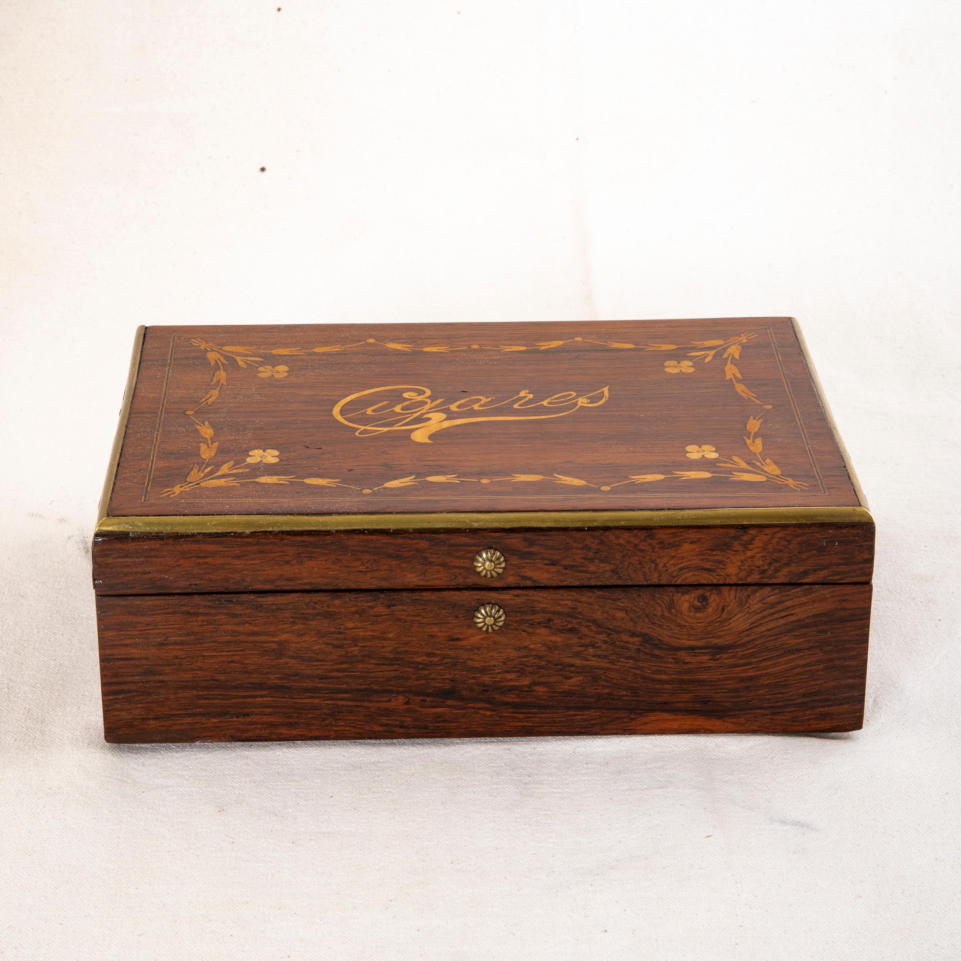 This mid nineteenth century French Napoleon III period marquetry cigar presentation box is constructed of rosewood and is marked Cigares on the top in lemon wood inlay.  Additional inlay of garlands and flowers surround the central designation of