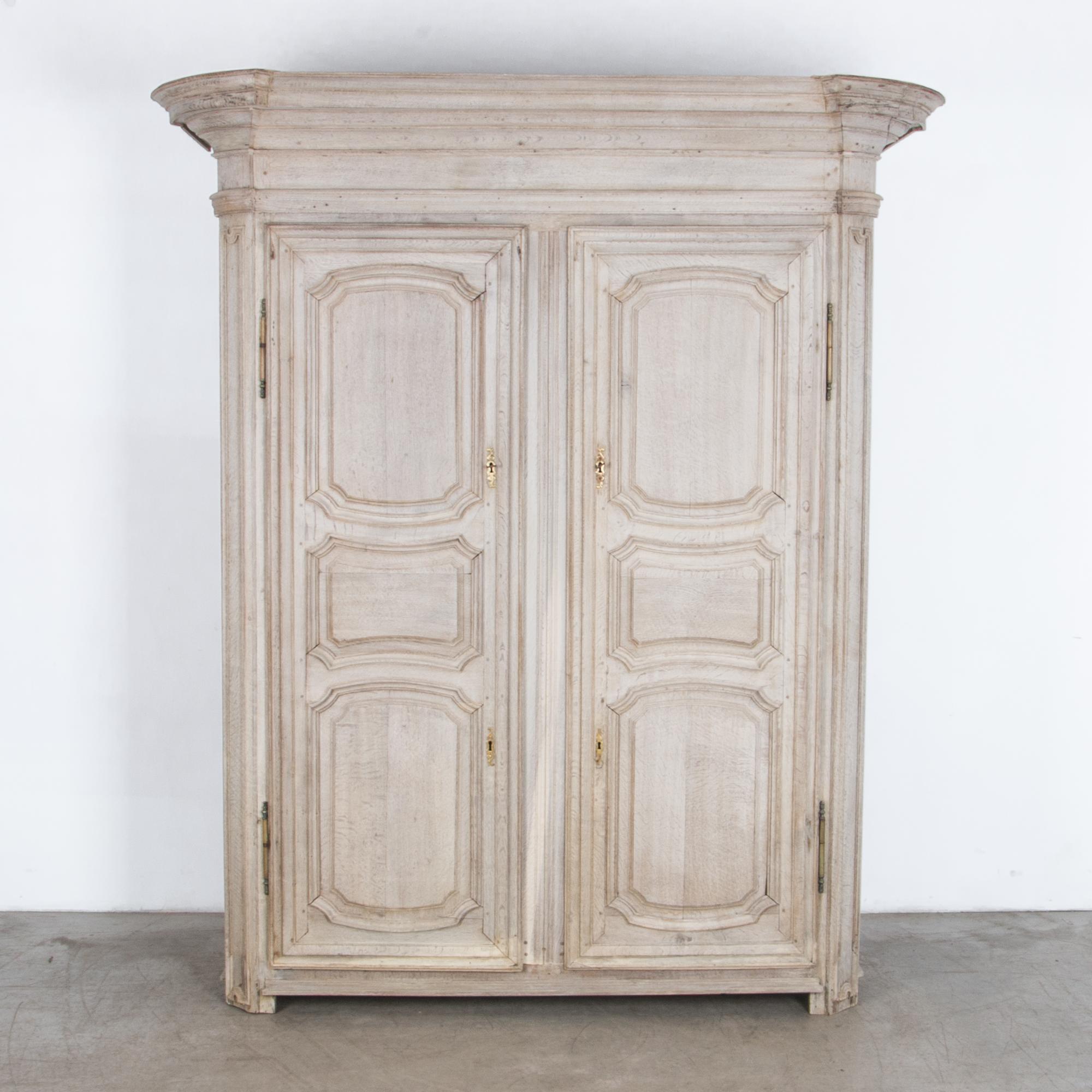Time tested traditional craftsmanship, with distinctive cold growth oak in a rustic neutral finish and original brass hardware. A practical and beautiful storage piece with interior shelving and impressive moulding elements. This elegant wardrobe is