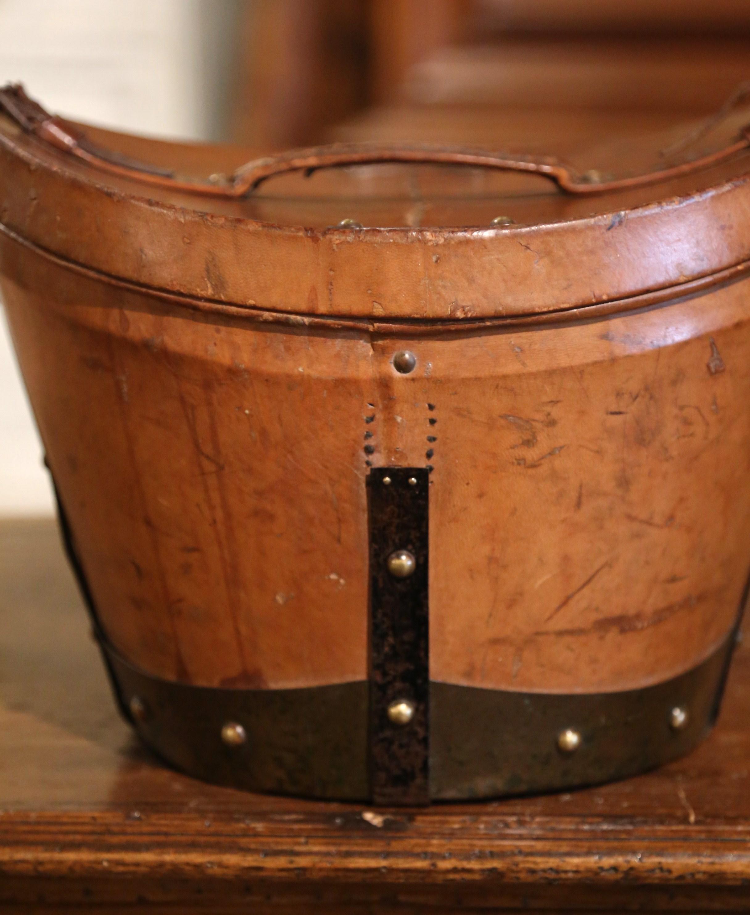 This exquisite, antique pigskin box was crafted in Rouen France, circa 1870. This leather box features leather straps and handle embellished with decorative brass nail heads, and the inside is dressed with the original red upholstery; the piece also