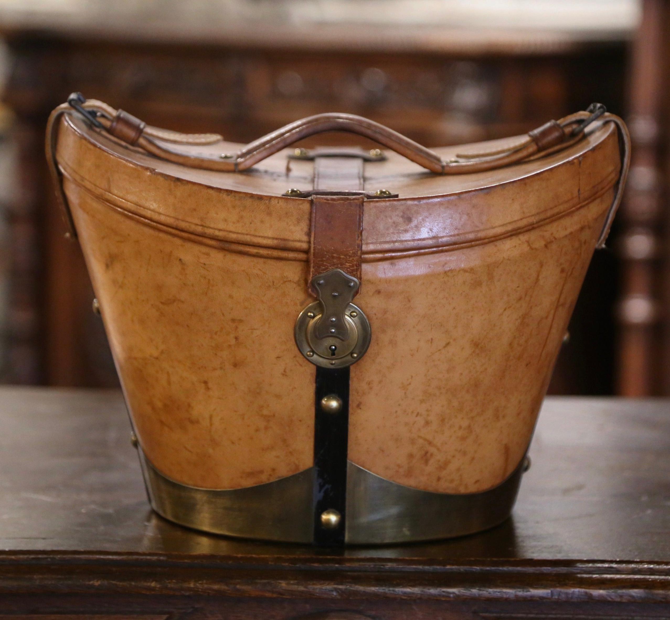 This exquisite, antique pigskin hat box was crafted in Rouen France, circa 1870. This leather box with brass bottom, features leather straps and handle embellished with decorative brass nail heads, and the inside is dressed with the original red