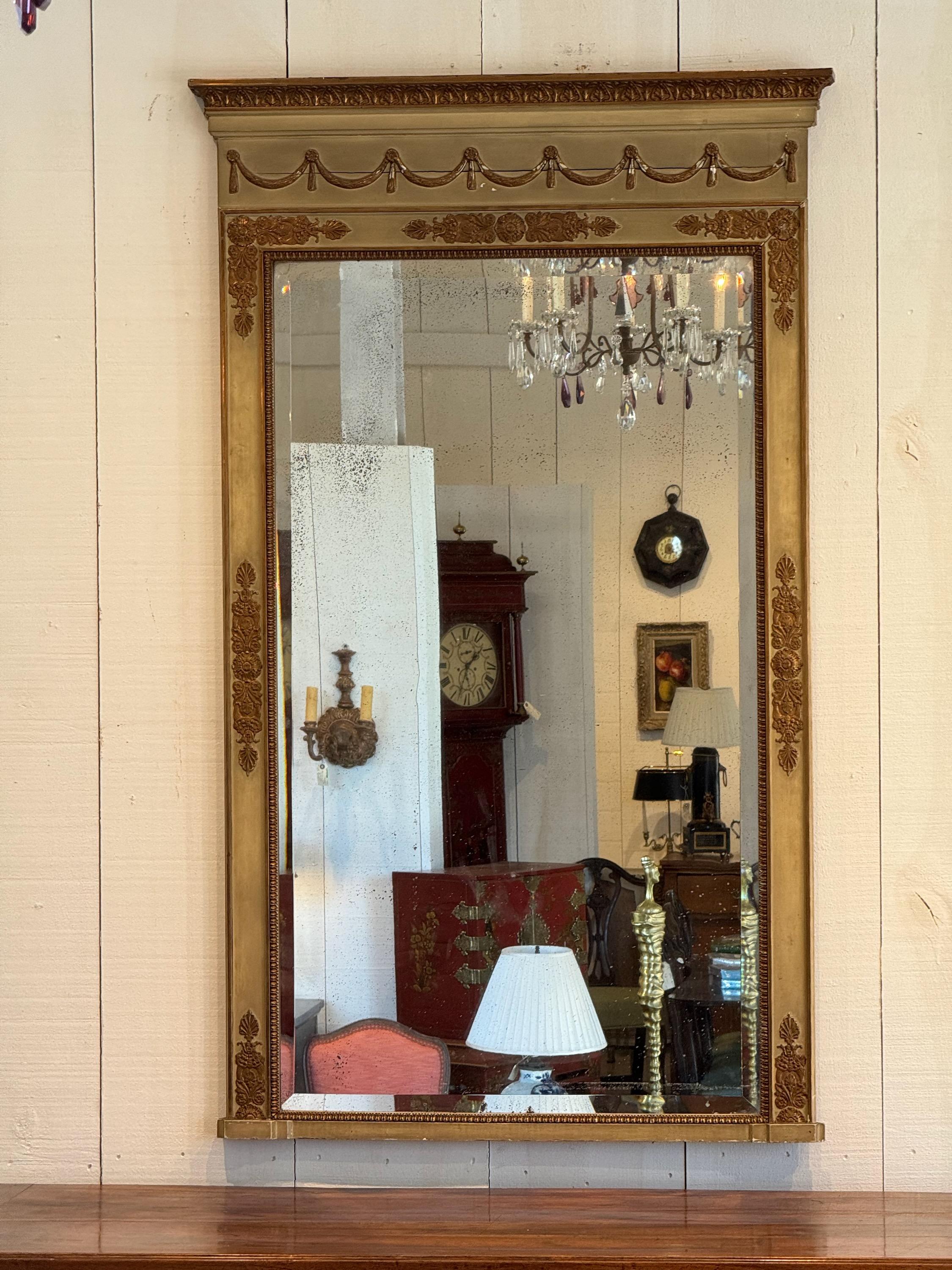 A paint and gilt decorated mirror. The light wear to paint and gilding adds much charm.