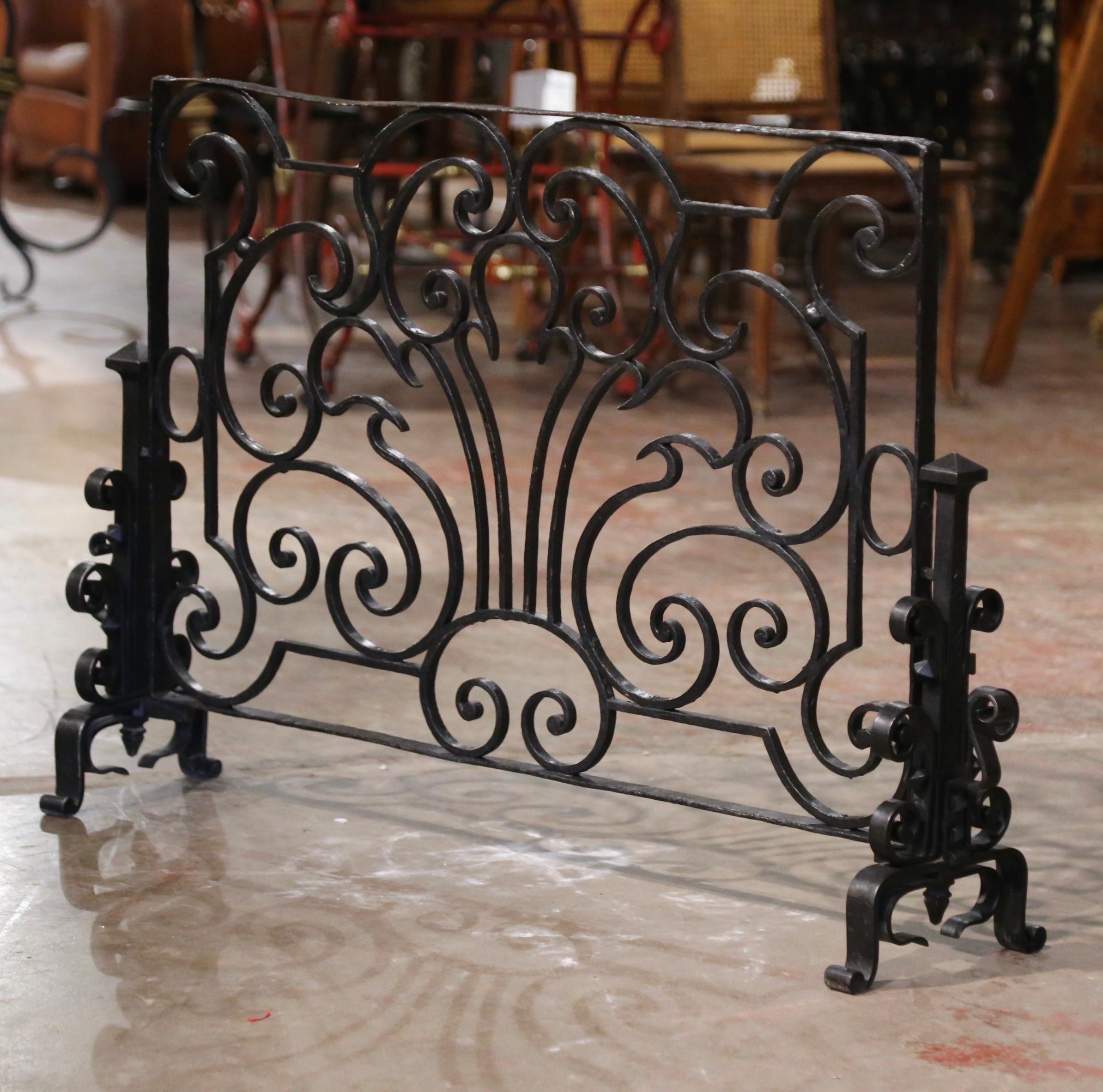 Decorate a fireplace hearth with this elegant freestanding antique hammered iron screen. Hand forged in France circa 1860, the tall wrought iron screen stands on curved feet at each end and features decorative scroll motifs throughout. The heavy