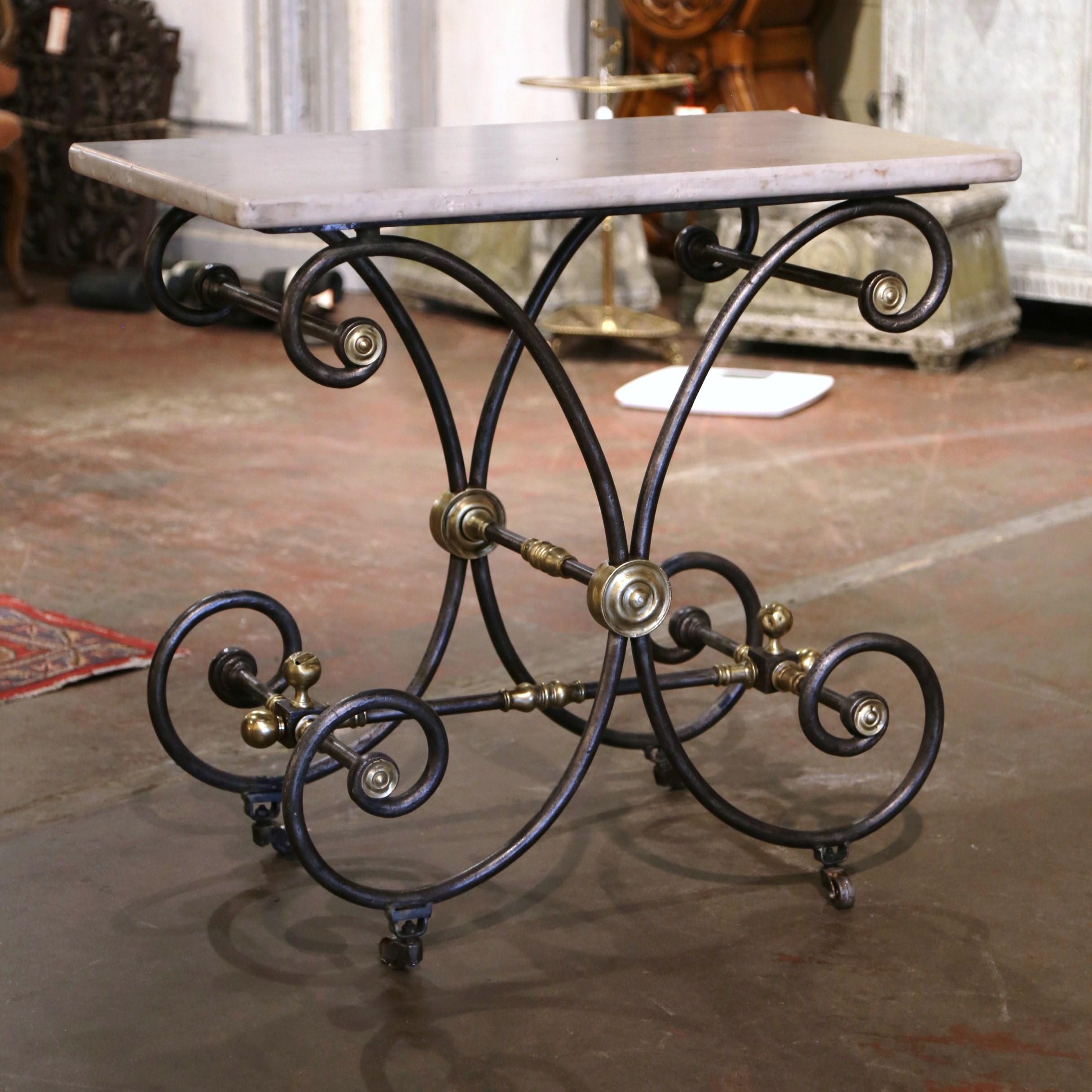 Rectangular in shape, the petite antique butcher table (or pastry table) would add the ideal amount of surface space to any kitchen. Crafted in France circa 1860, the table features intricate metal work and beautiful scrolled legs, decorated with