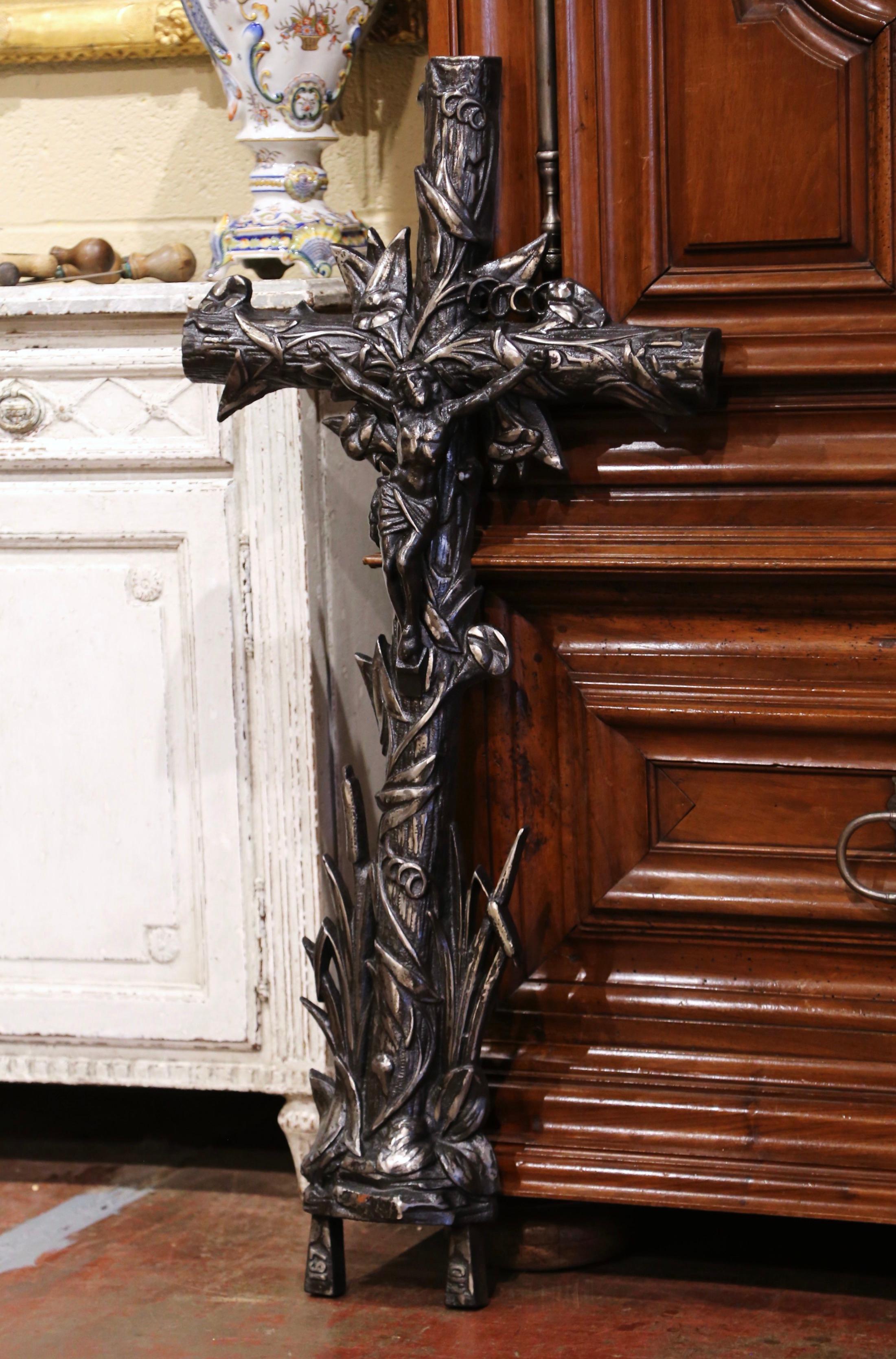 Dieses schöne, antike Kreuz wurde um 1870 in Frankreich hergestellt. Das große eiserne Kruzifix ruht auf einem ovalen Sockel und zeigt den an das Kreuz genagelten Herrn. Es ist durchgängig mit Weinreben- und Schilfmotiven in Hochrelief verziert. Die