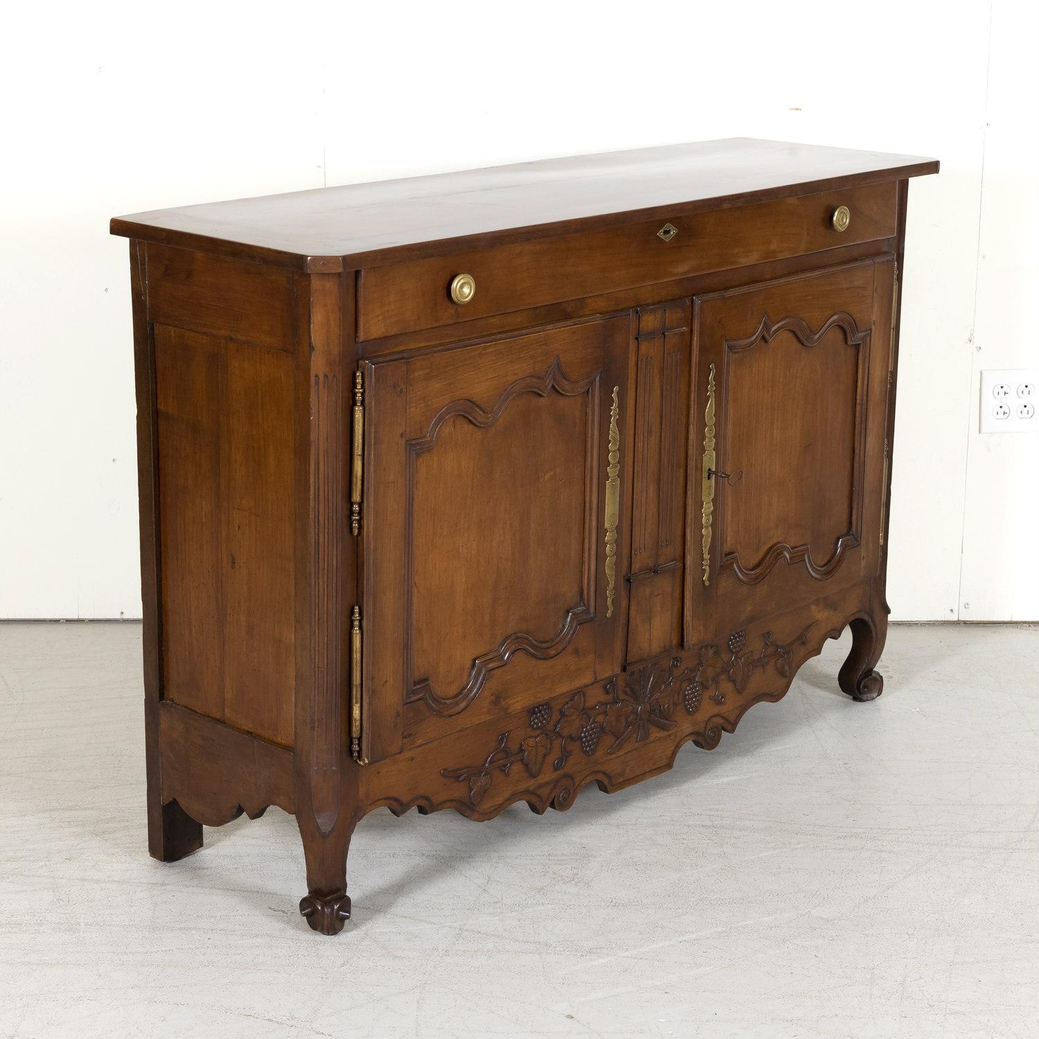 A fine mid-19th century French Provincial Louis XV style buffet Nantais handcrafted by talented Breton artisans of solid cherry near Nantes, a city on the Loire River in the Upper Brittany region of western France, circa 1850s. This graceful buffet