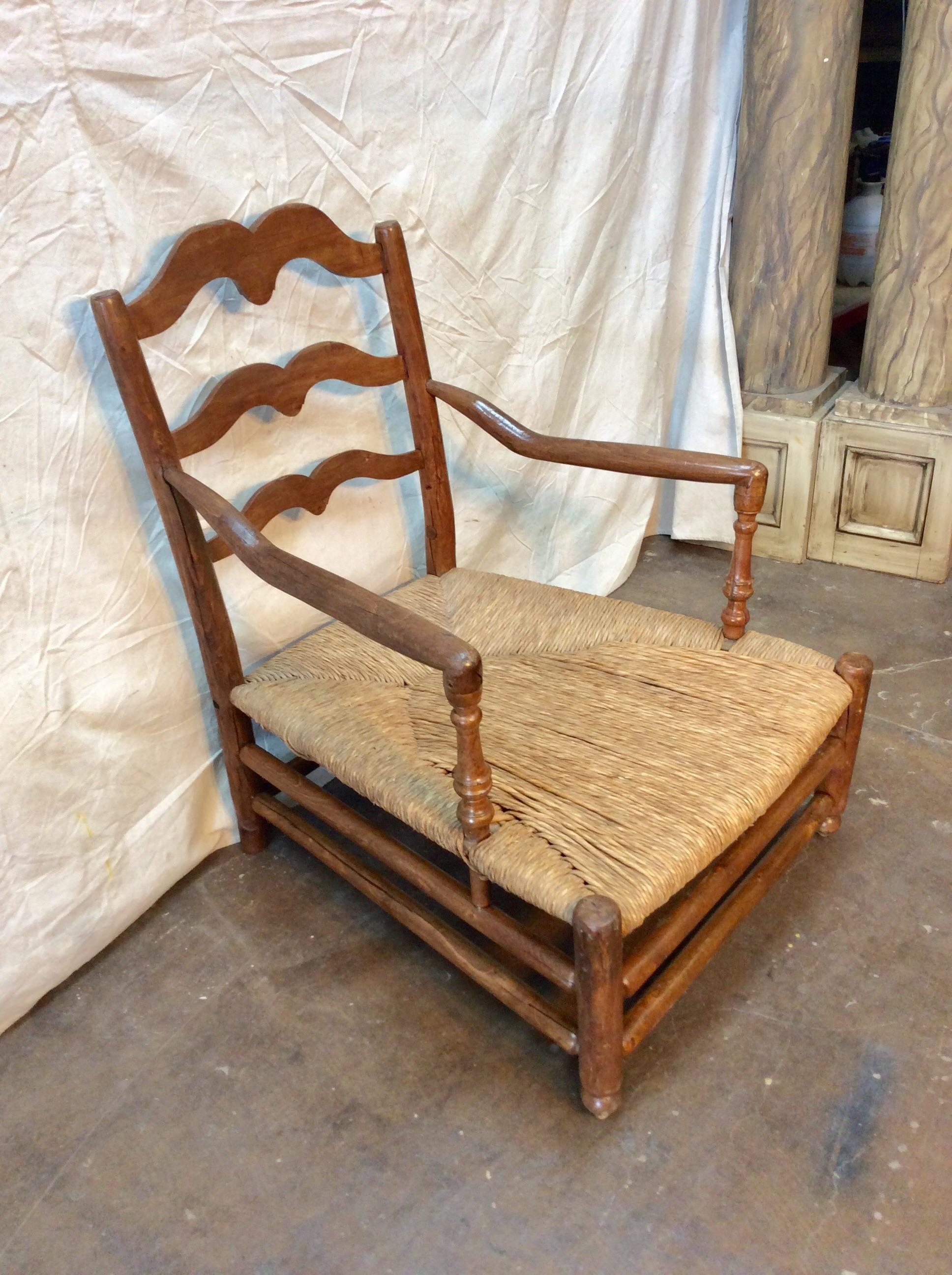 Found in the South of France this mid 1800s French Rush Seat Lounge Chair features a rush seat created by using a weaving technique where long, dried grass-like vegetation is used. The fauteuil armchair or lounge chair was constructed with a high