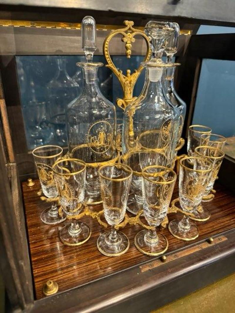 Mid-19th Century French Tantalus in Rosewood Carrier with Beveled Glass.
This beautiful bar set is both incredible in design and function. Gold accents on the glassware gives this set an extraordinary appeal. Set includes eight drinking glasses and