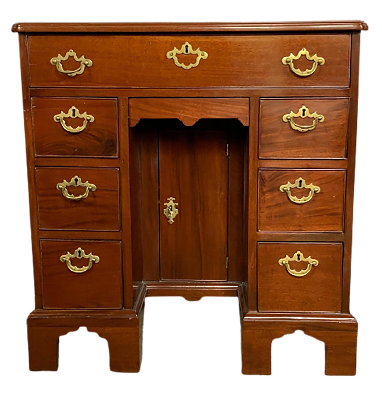Mid-19th century Georgian style mahogany knee hole desk in very nice original condition. The case having a single top drawer with a knee hole center flanked by three by three drawers and a center hidden door in the knee hole area. The whole on