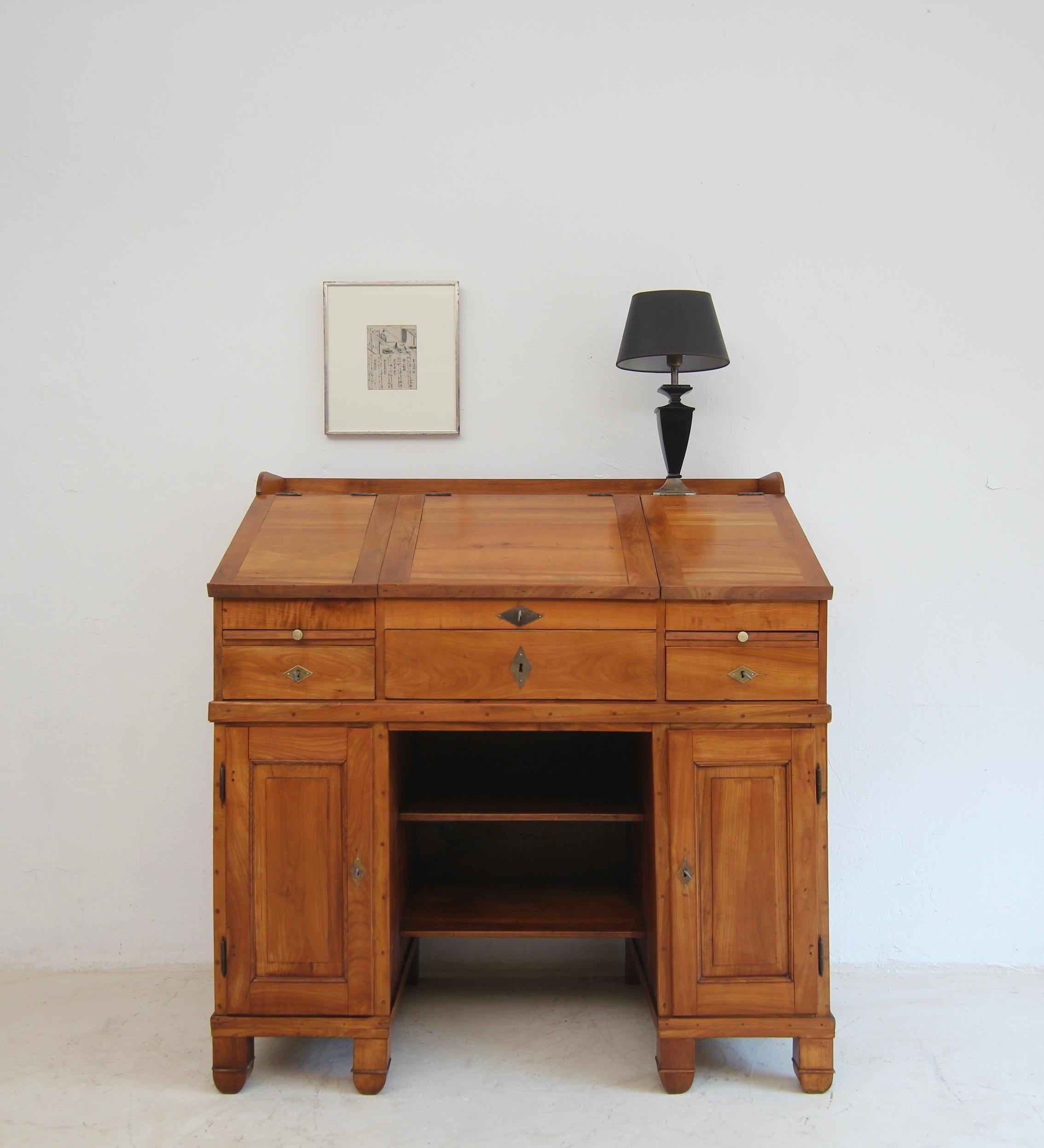 Large Biedermeier standing desk or writing desk. West German/Rhineland, around 1840. Solidly crafted from cherry wood.
An authentic piece of Biedermeier furniture with an elegant design that follows the ideals of clarity, order and utility.

It is