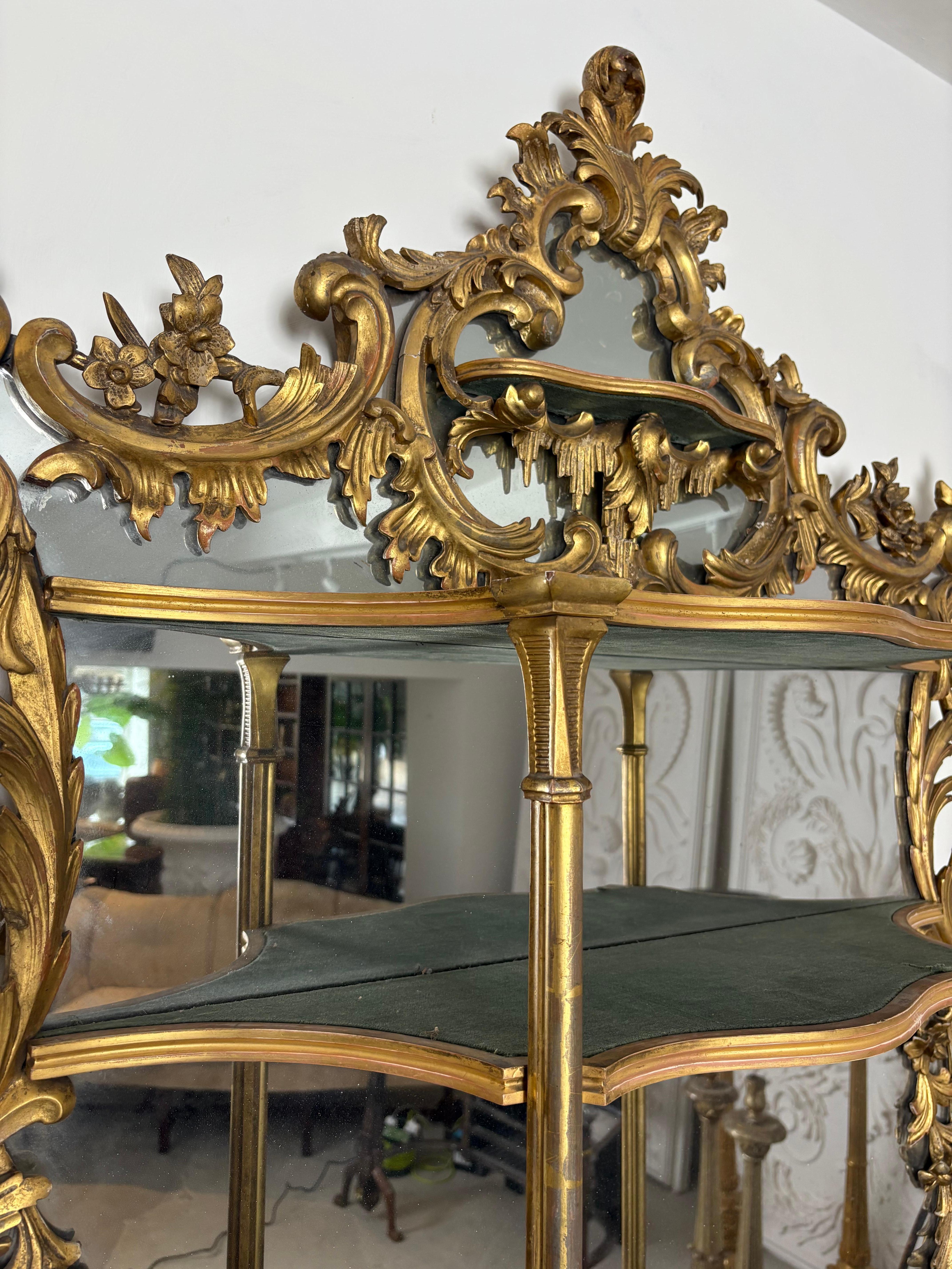 An exceptional Mid 19th Century Giltwood hand carved Rococo mirror with five shelves.
Decorated with carved scroll work ,acanthus leaves,flowers and icicles . The structure of the shelves is in a serpentine form supported by pilasters, with a