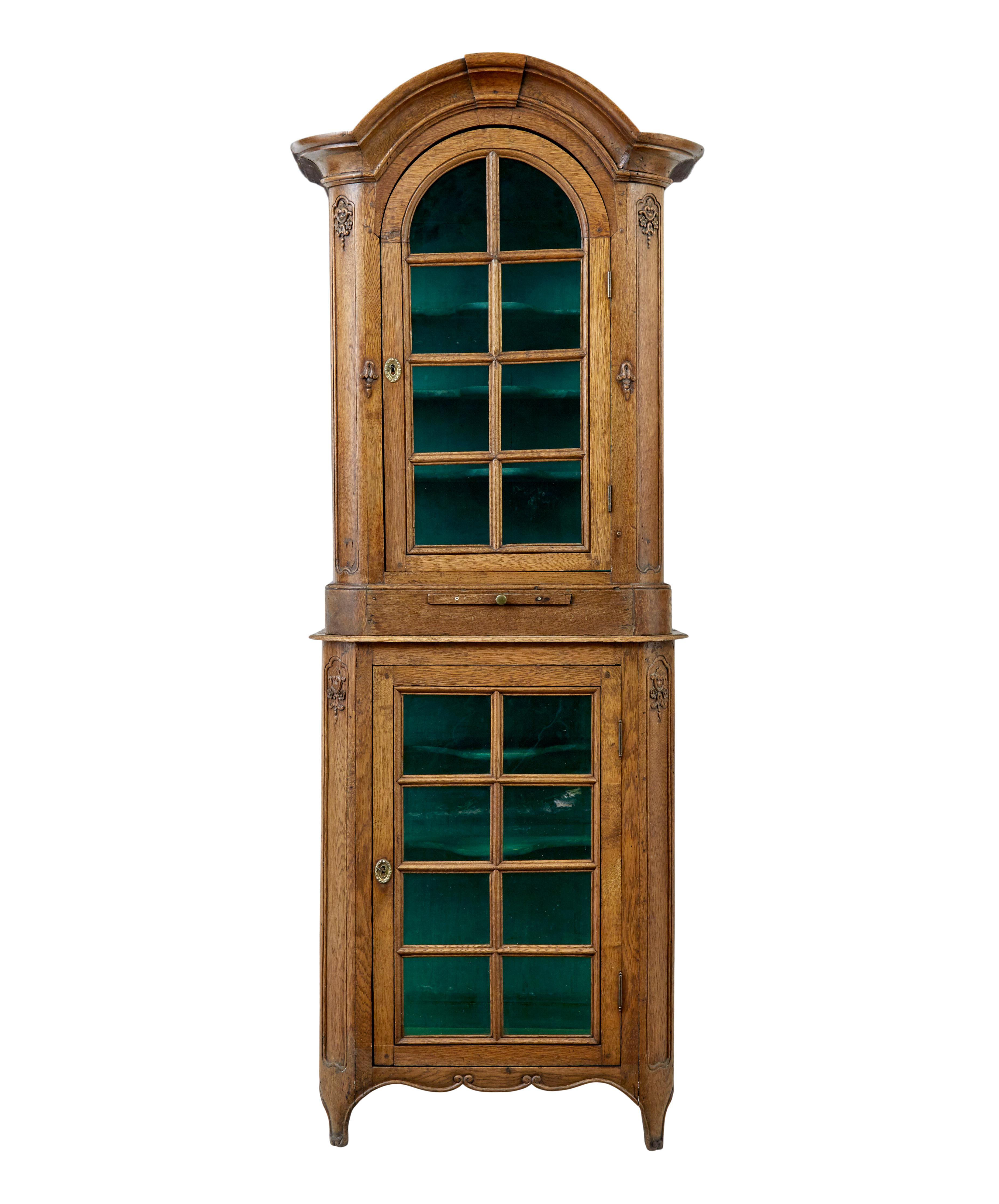 Mid 19th century glazed carved oak liege cabinet circa 1860.

Beautiful 2 piece liege cabinet from Belgium presented in oak, original green coloured glass and contrasting painted interior.

Top section with carved architectural cornice, rounded
