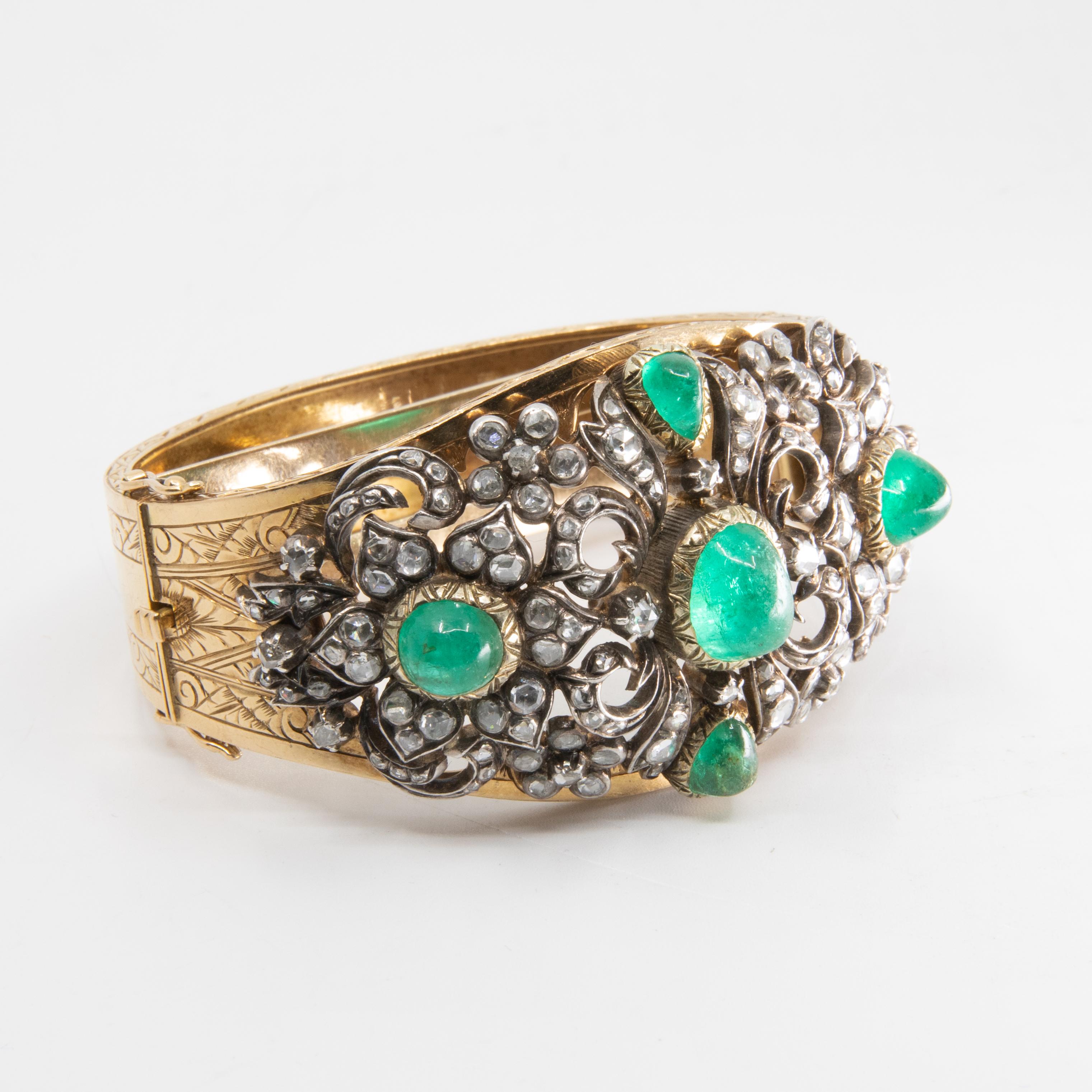 Mid 19th century 22 carat white and yellow Gold, Emerald, and Diamond Bracelet, the hinged bangle set with cabochon emeralds and rose-cut diamonds set in 22 carat white gold. Engraved accents, 48.2 dwt, 