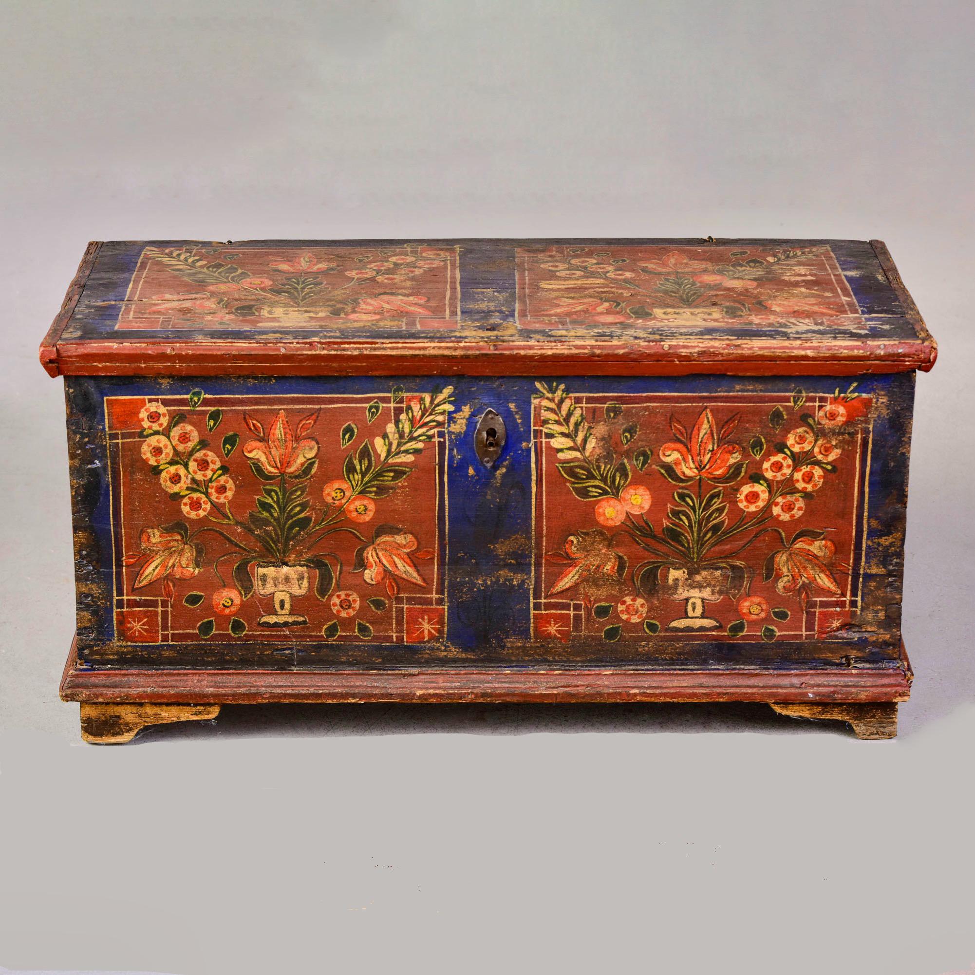 Circa 1865 Romanian painted wood trunk. Great color and design with floral motif and painted panels on top, front and sides. Honest wear and fading. Painted date inside of lid is 1865. Rustic hinge hardware, dovetail construction, small internal