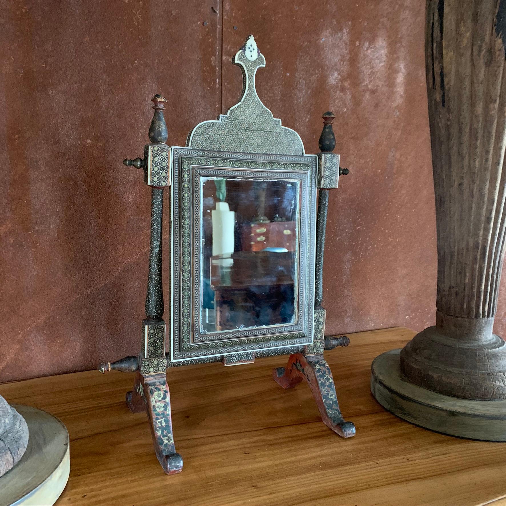 A stunning mid-19th century Indian dressing table mirror with intricate micro mosaic design, known as Sadeli. The micro mosaic pieces comprise of brass, bone and colored woods, placed in geometric and star configurations. The base and finials of the