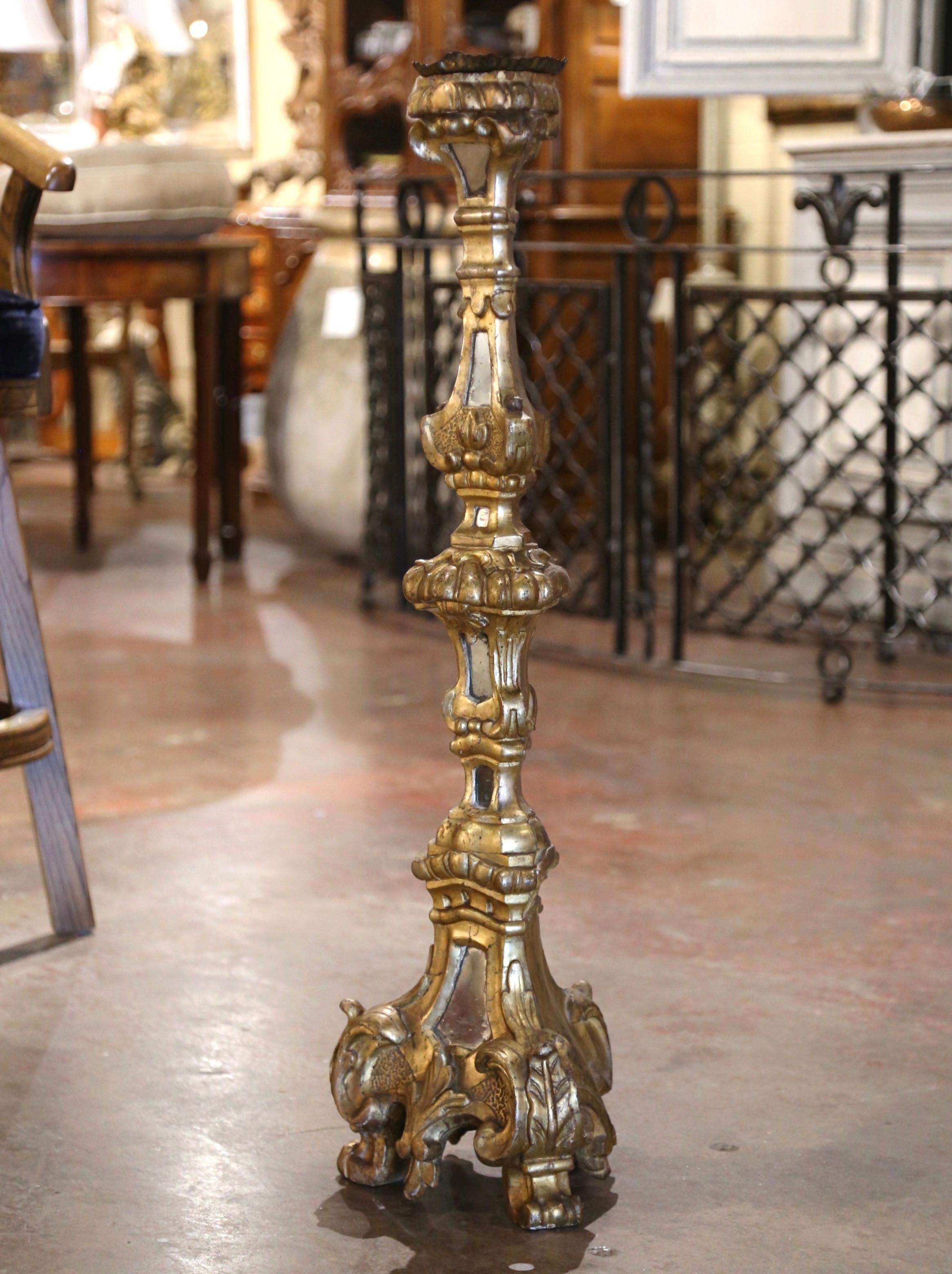 Dieser elegante antike vergoldete Kerzenständer wurde um 1850 in Italien hergestellt. Über 3 Fuß in der Höhe und stehend auf drei Klauenfüßen über einer dreieckigen geschnitzten Basis, die mit Akanthusblattmotiven verziert ist, weist der hohe