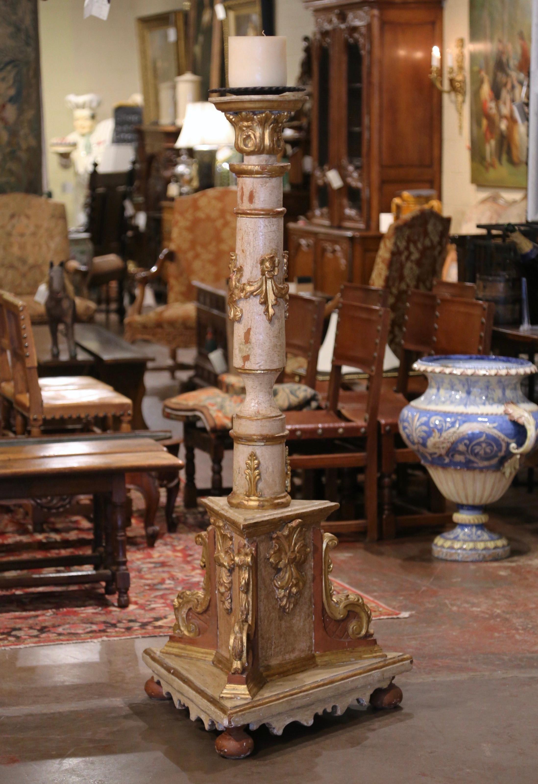 Standing at 6 feet tall, this antique torchere was crafted in Italy, circa 1860. The elegant candle holder stands on a wide triangular base ending with bun feet over a tripod bottom decorated with scroll and shell motifs in high relief. The large