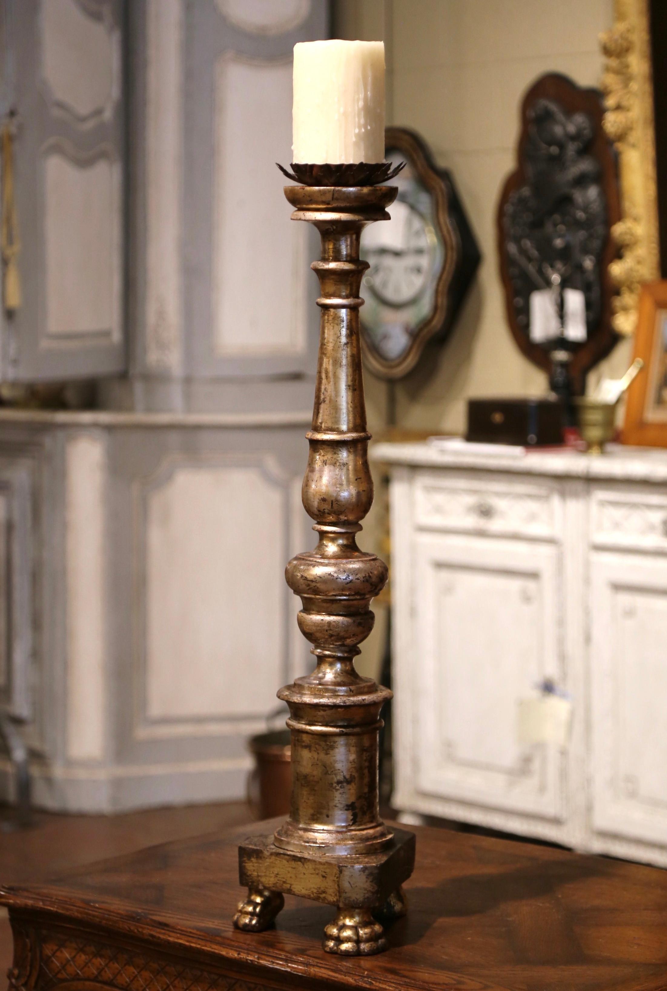 This elegant antique candle holder was created in Italy circa 1860. Standing on three paw feet over a triangular base, the tall candlestick features a carved stem dressed with a metal bobeche at the pediment. The dramatic, embellished candle holder