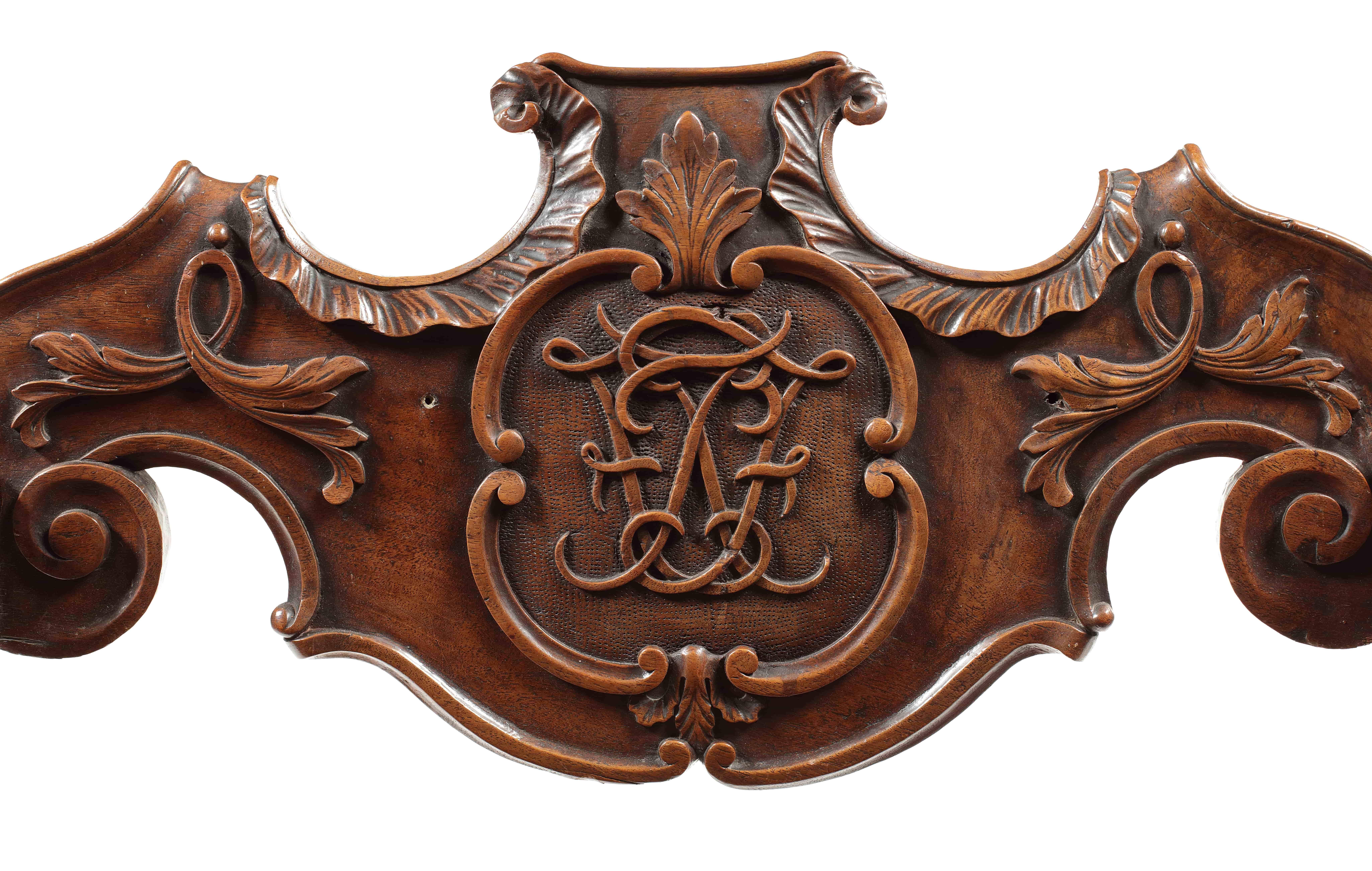 The shaped acanthus carved scrolling panelled back with central cypher monogram with a 'C' scroll border, the scroll arms with slatted sides and seat joined by a turned roundel on 'X' form legs carved to the front with acanthus leaves on scrolling