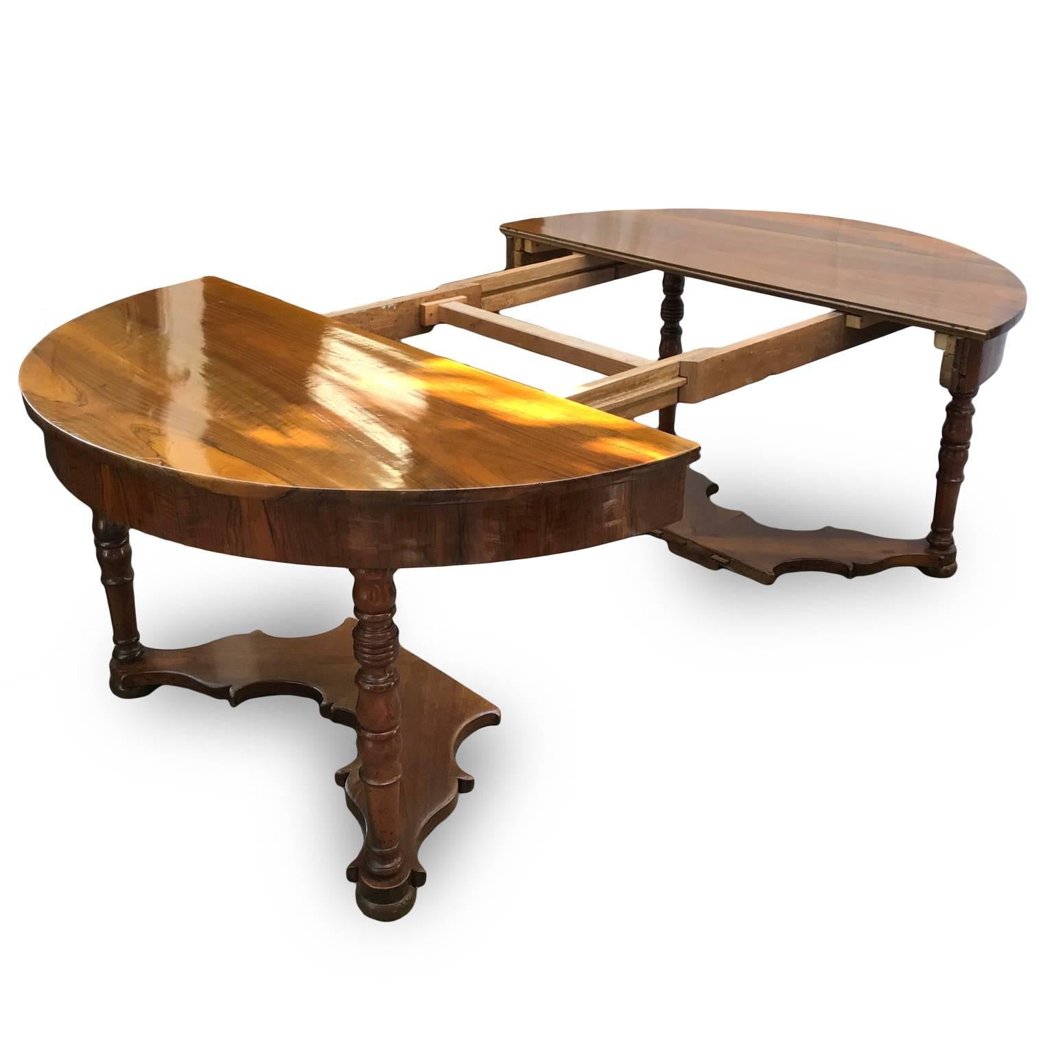 A Louis Philippe extendable walnut dining room table dating back to mid-19th century and coming from Bologna, in overall good condition. This antique Italian almost circular table has an extensible solid walnut top, with a superlative flamed walnut,