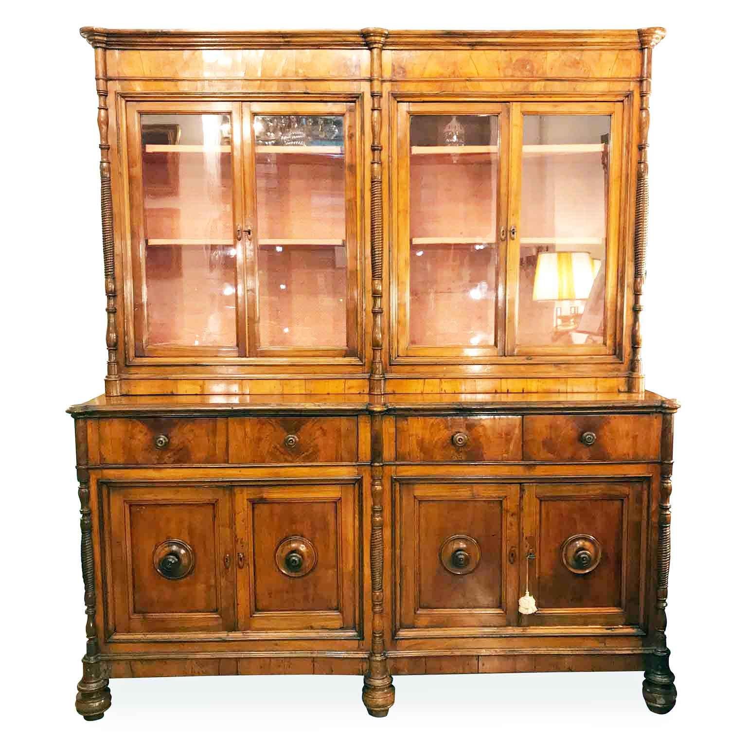 This stunning cherry four-door bookcase on cupboard dates back to mid-19th century, it is a two-part cabinet of Northern Italian, Lombard origin. 
It comes from a private villa in Milan and it is in good age related condition, with minor signs of