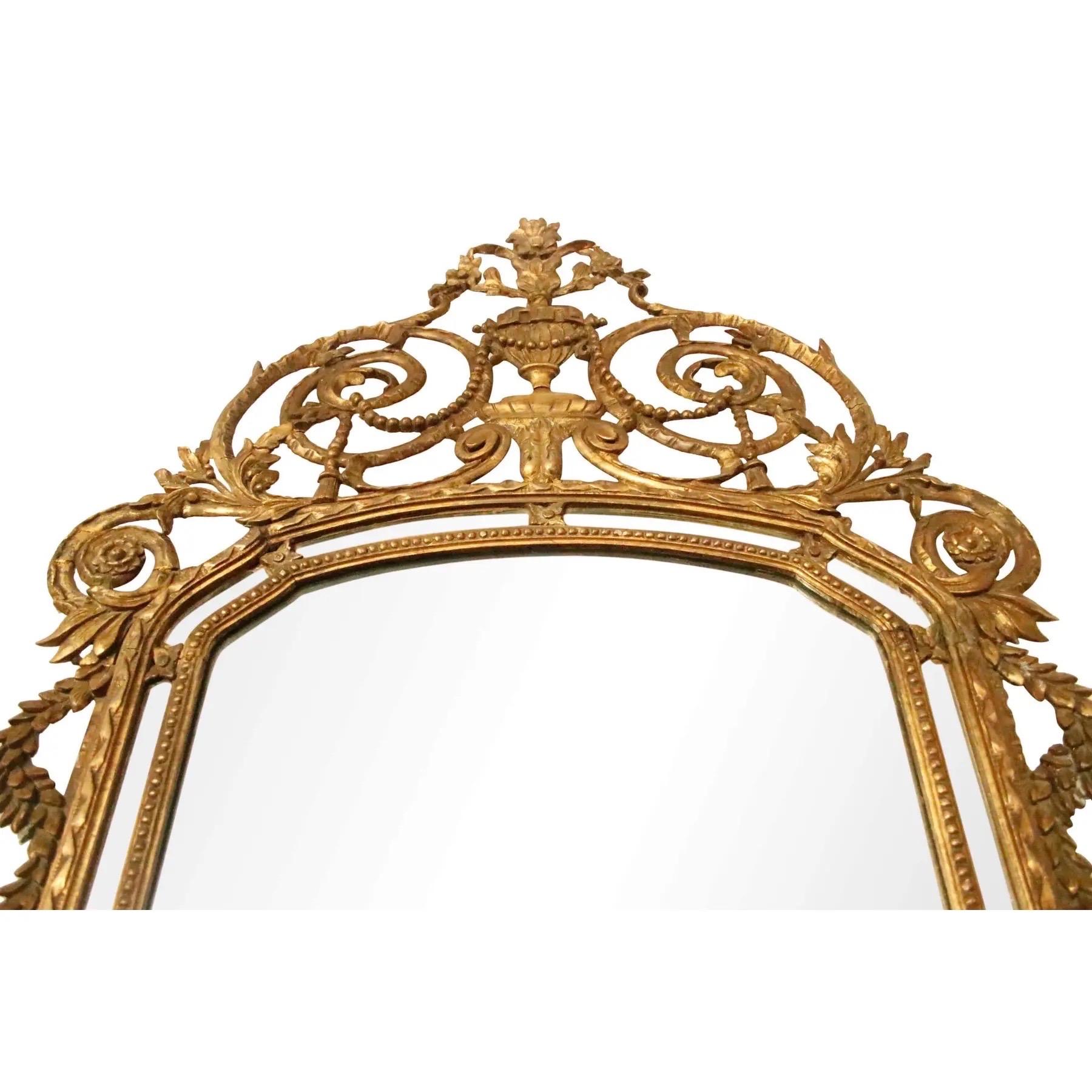 Miroir italien en bois doré vers 1850. Encadré de perles sculptées et d'un ruban à volutes sur le bord du miroir, le cadre est décoré d'acanthes à volutes élaborées.  et des feuilles pendantes. Le cimier est orné d'un vase avec des perles enfilées