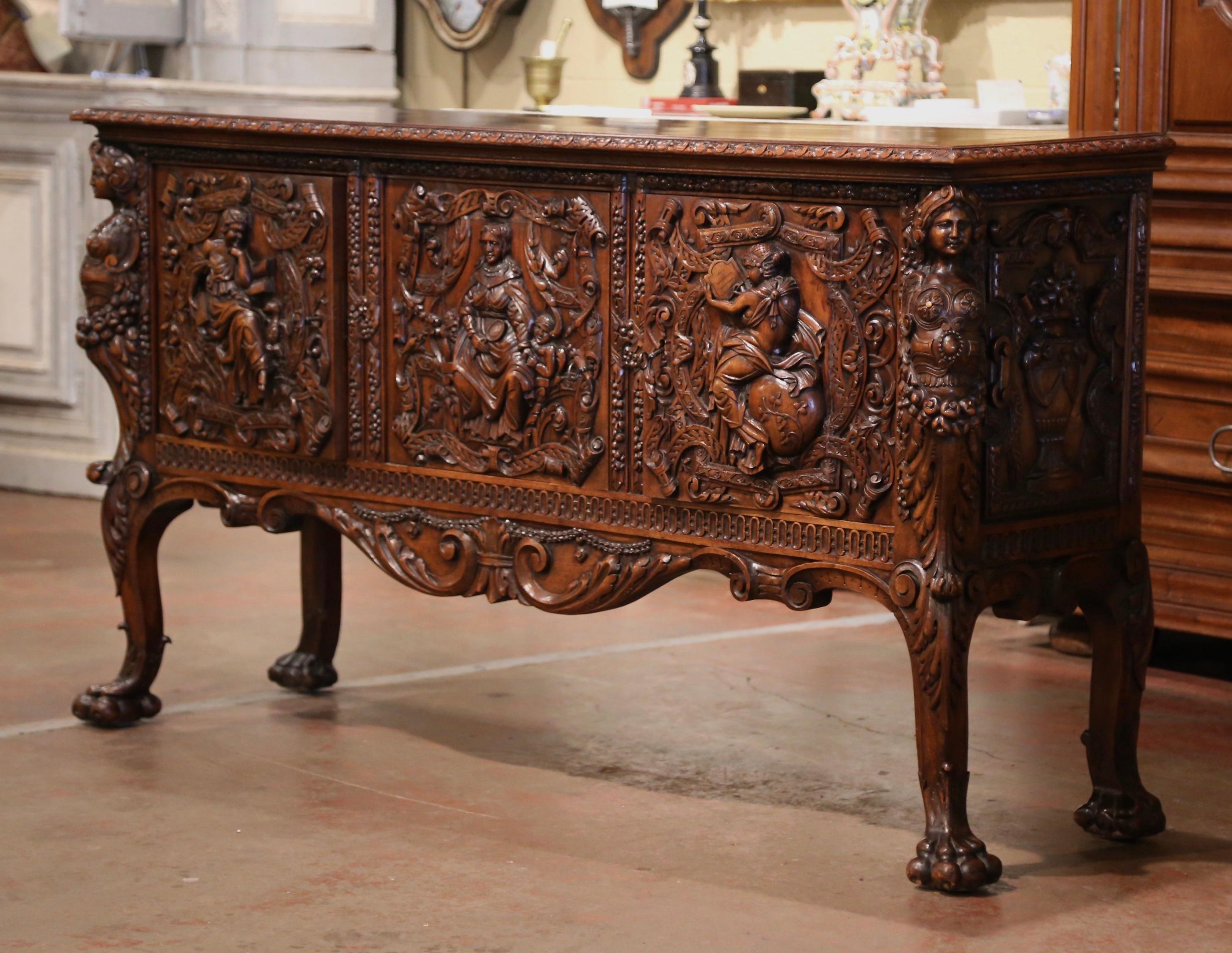 This heavily carved credenza was created in Italy circa 1870. Built of solid walnut, the buffet stands on elegant cabriole legs decorated with acanthus leaves at the shoulders, and ending with paw feet. The cabinet features three doors across the