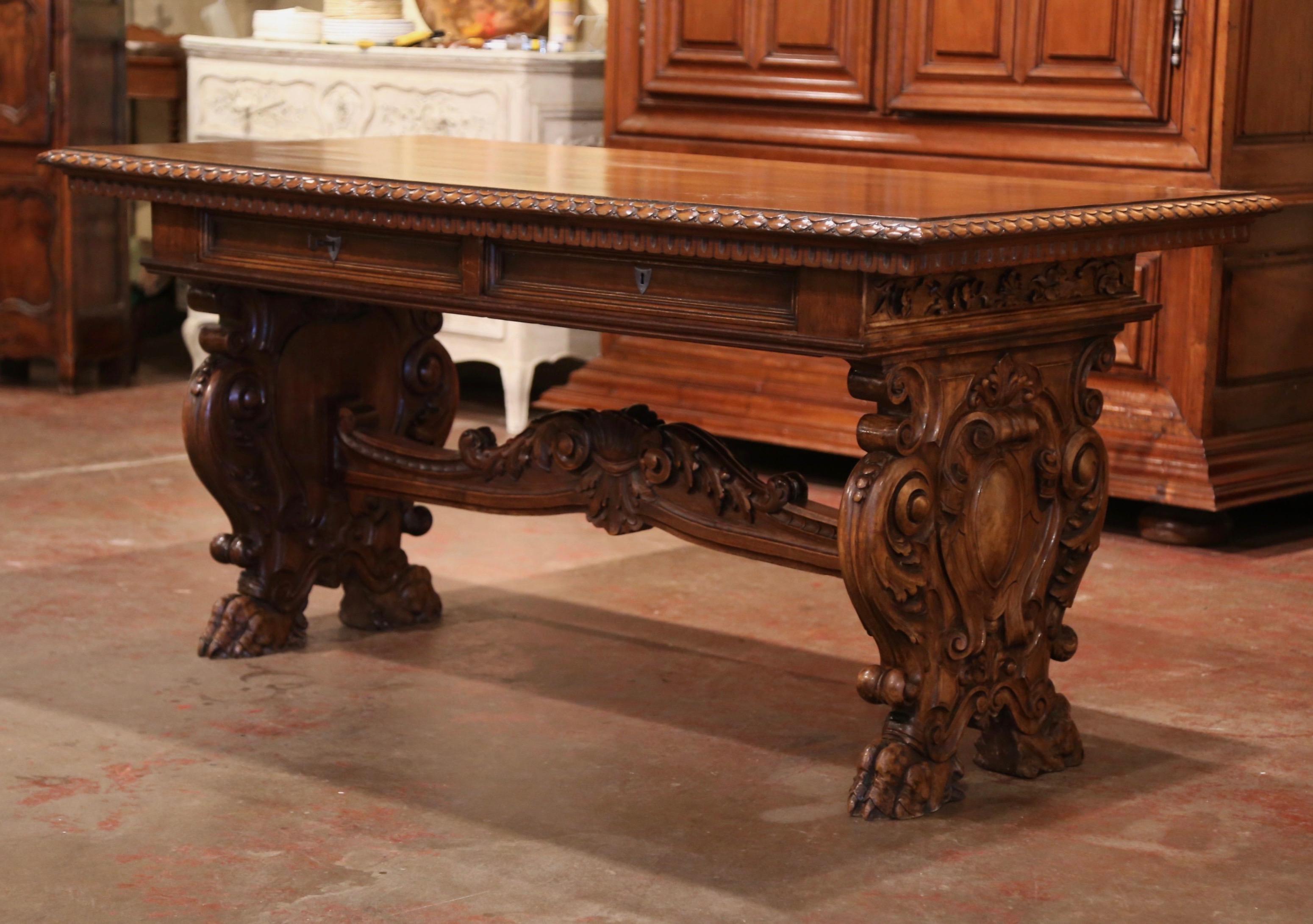 Bring the Italian elegance in your office with this important, antique Renaissance revival writing table. Crafted in Italy circa 1870, the impressive, fruitwood trestle table stands on two carved pedestal legs ending with paw feet. Both scrolled