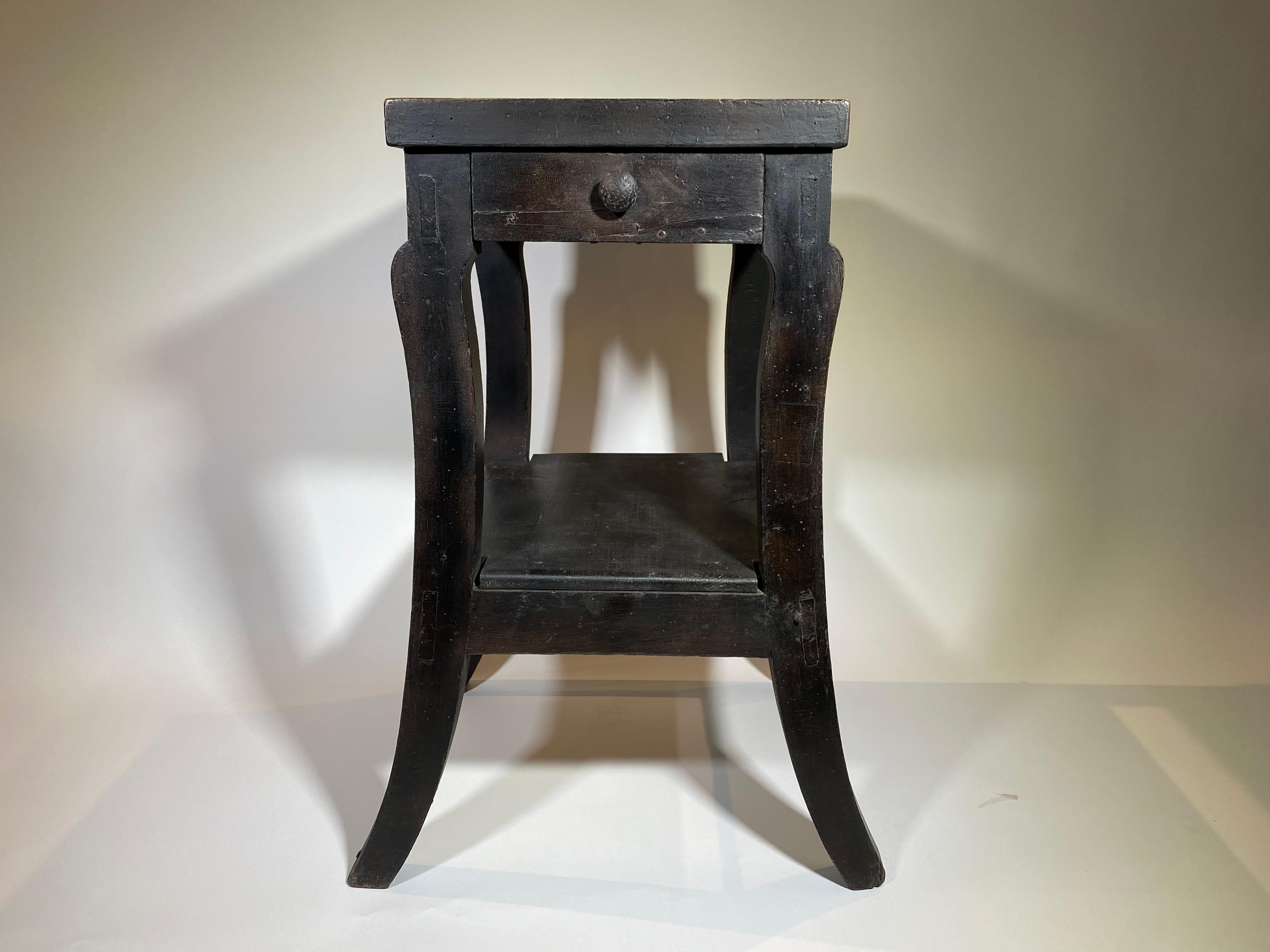 A charming mid-19th century side table from Northern Italy in painted wood. Fabulous finish and patina. A lovely shape with splayed legs, one drawer and centre shelf.
