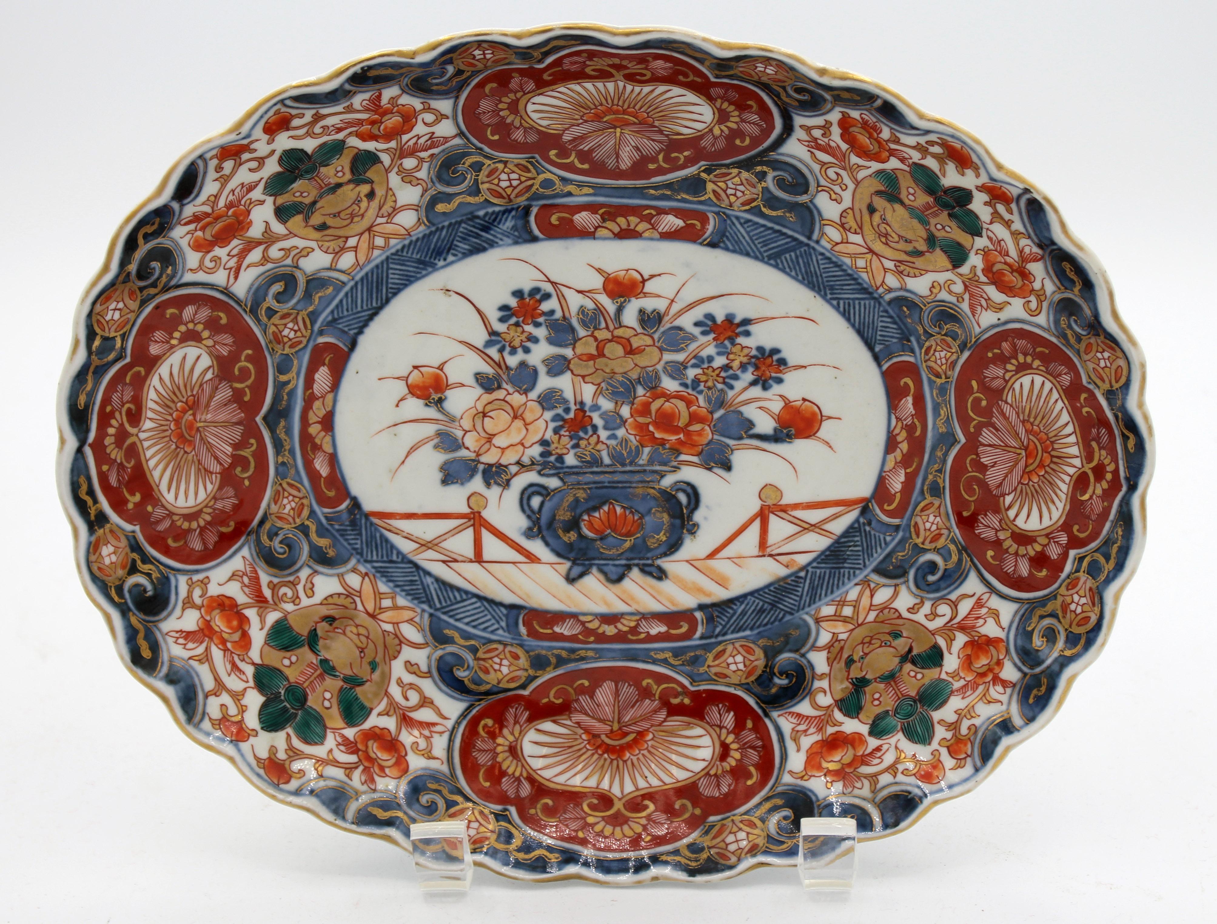 Late Edo period, c.1860, small Imari oval platter. Ribbed body superbly decorated with an urn of peonies in the central reserve is surrounded by eight small reserves, four with deep green and gilt kylin guardians. Measures: 9 7/8