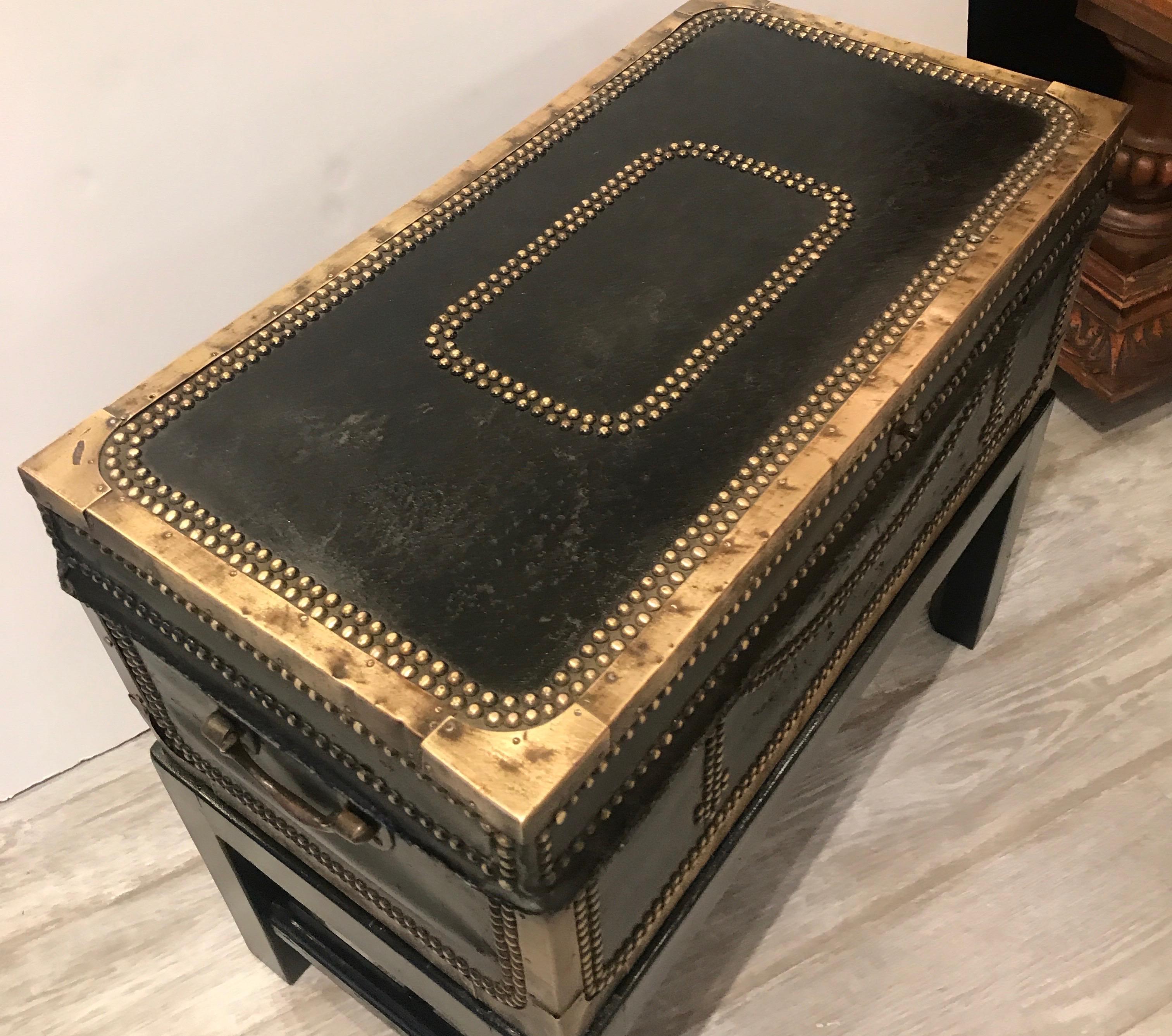 Handsome antique leather cased trunk on stand. An English leather covered trunk with brass nail head trim and corners. The original leather with age appropriate wear but has been cleaned and conditioned. The trunk is 19th century with a later custom